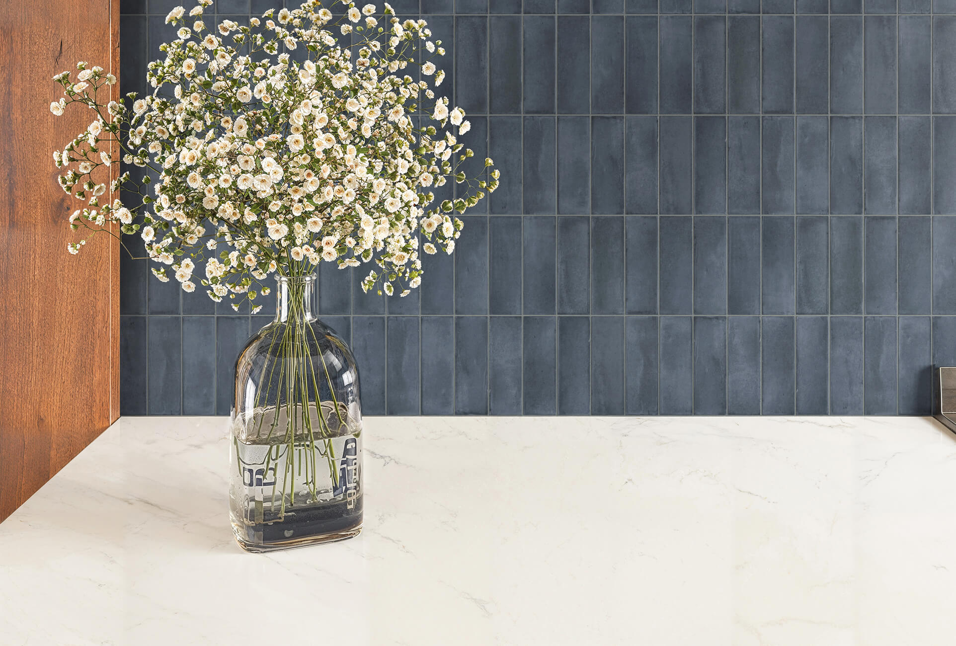 null Matte navy vertical subway tiles with a marble countertop for a bold and modern touch.