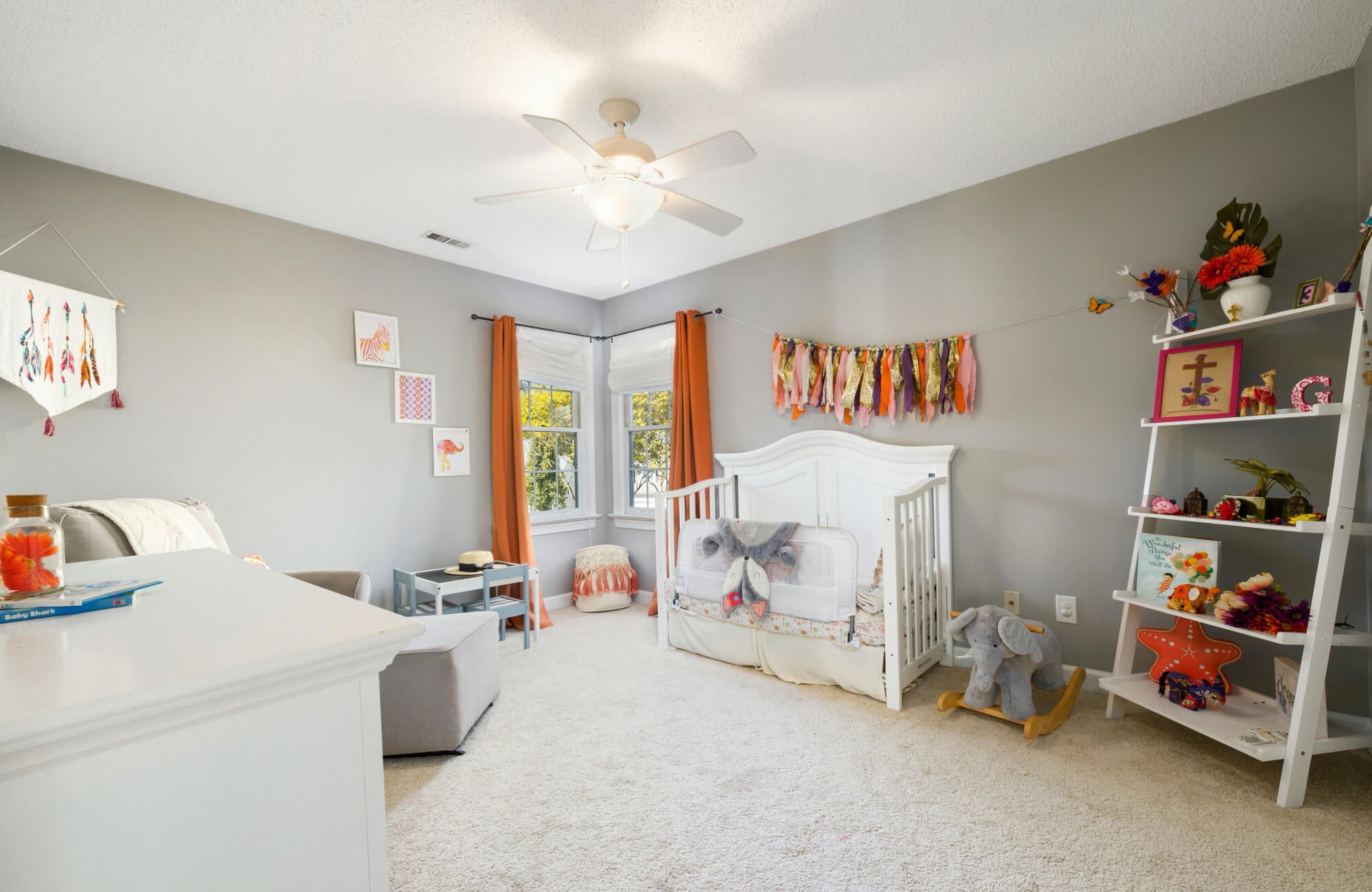 Wall to wall nursery carpet with a defined rug zone near the crib, providing soft coverage while leaving clear walking paths.