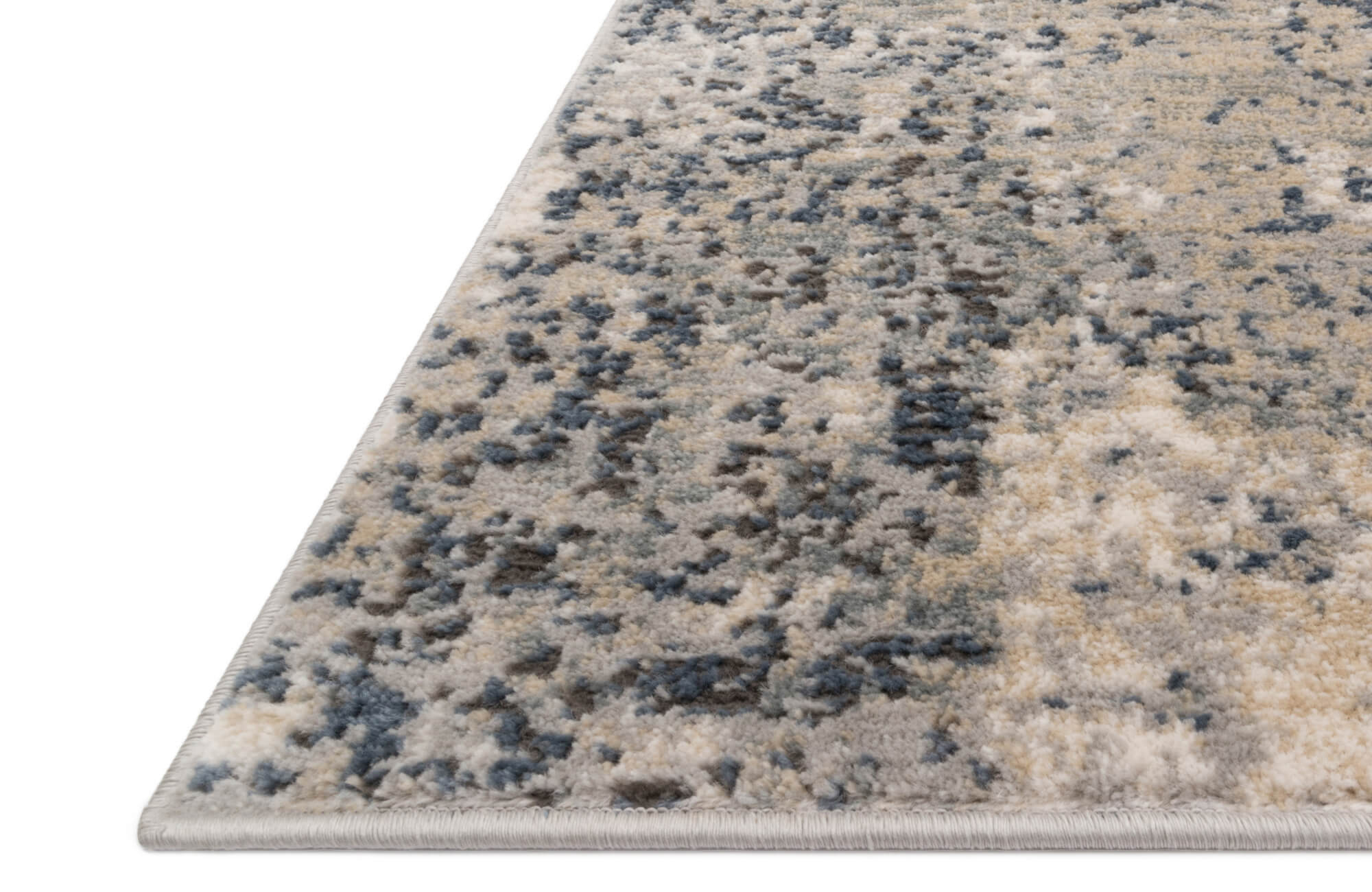Close-up of a plush area rug with a soft abstract pattern in muted blues, creams, and taupes for a modern touch.