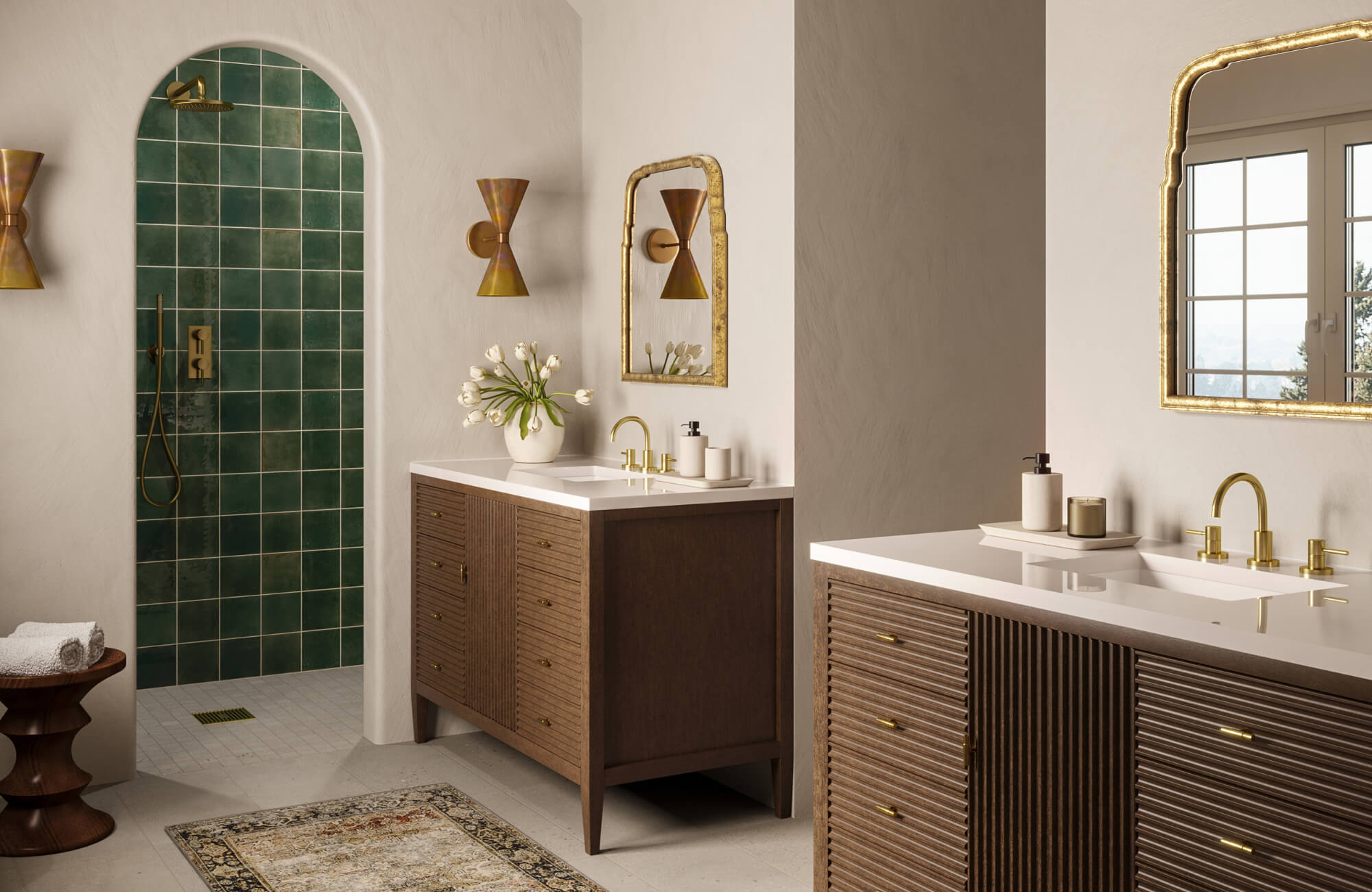 Bathroom with dual vanities, gold-framed mirrors, green tiled shower, and brass fixtures creating a warm, elegant, and balanced interior.
