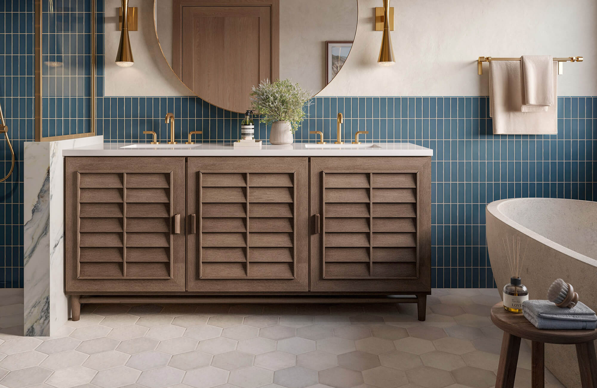Modern bathroom with wood vanity, blue vertical tile backsplash, beige hexagon floor tiles, round mirror, and gold fixtures for a warm finish.