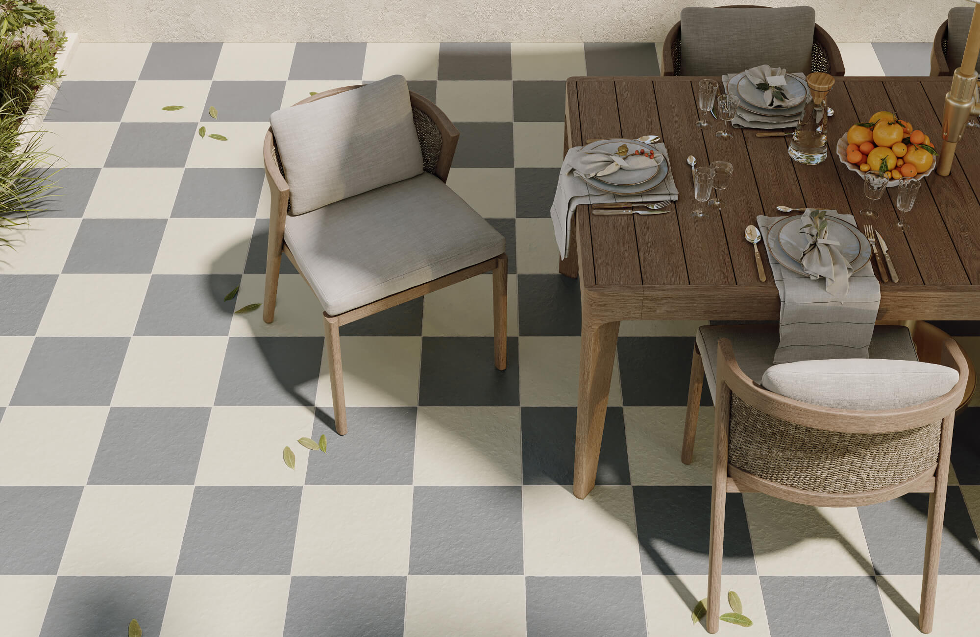 Outdoor dining area with checkerboard porcelain tiles in gray and cream, paired with a wooden table and neutral cushioned chairs.