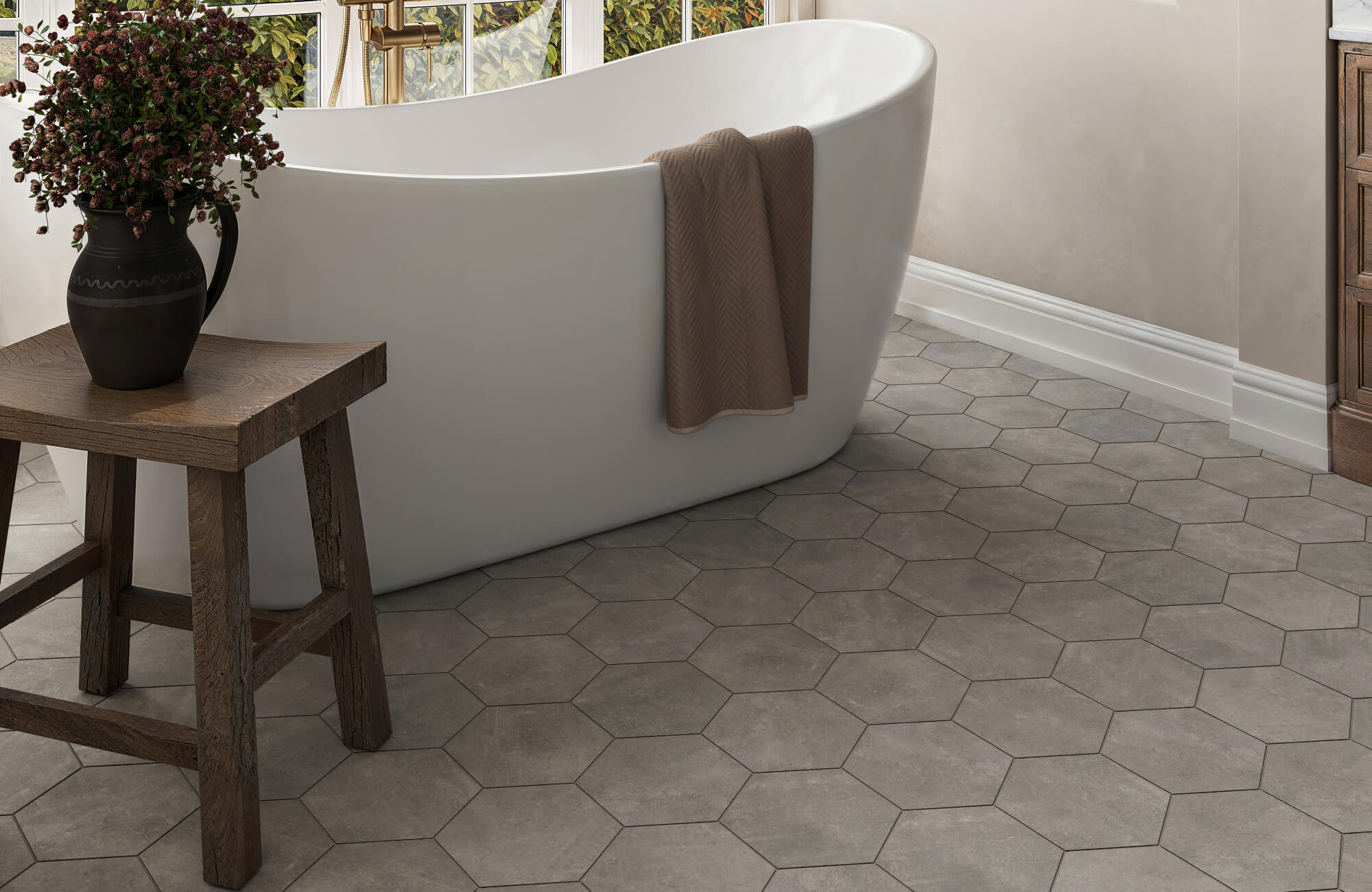null Serene bathroom with hexagonal cement look floor tiles in soft grey, complementing a freestanding tub and rustic wood accents.