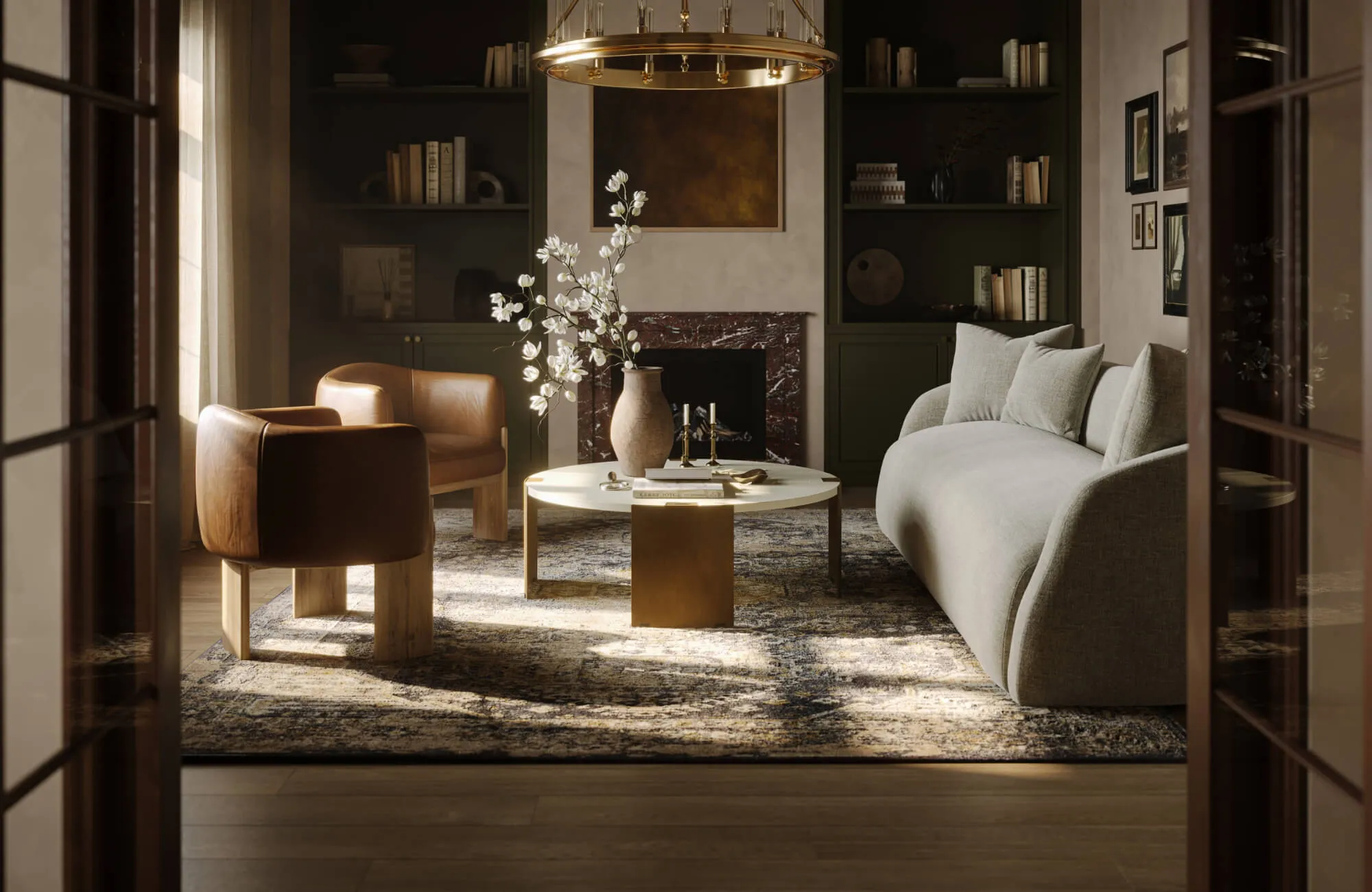 Warm living room with wood look tile flooring, a patterned area rug, tan leather lounge chairs, a curved gray sofa, and a round coffee table beneath a brass chandelier.