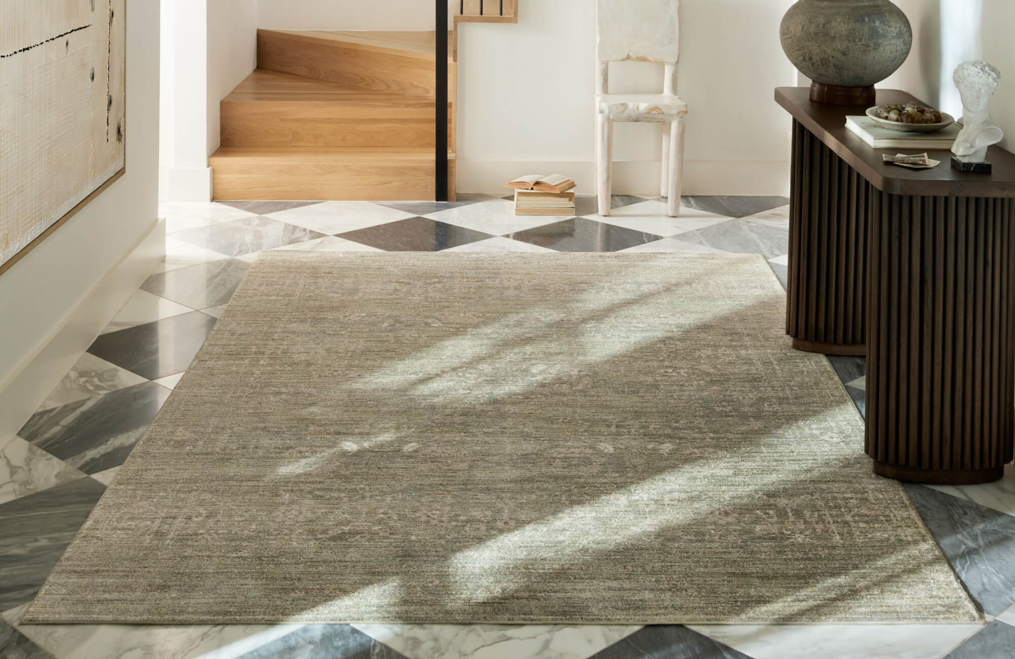 null Elegant entryway featuring a neutral-toned polypropylene area rug on a bold black-and-white marble floor, creating a sophisticated contrast.