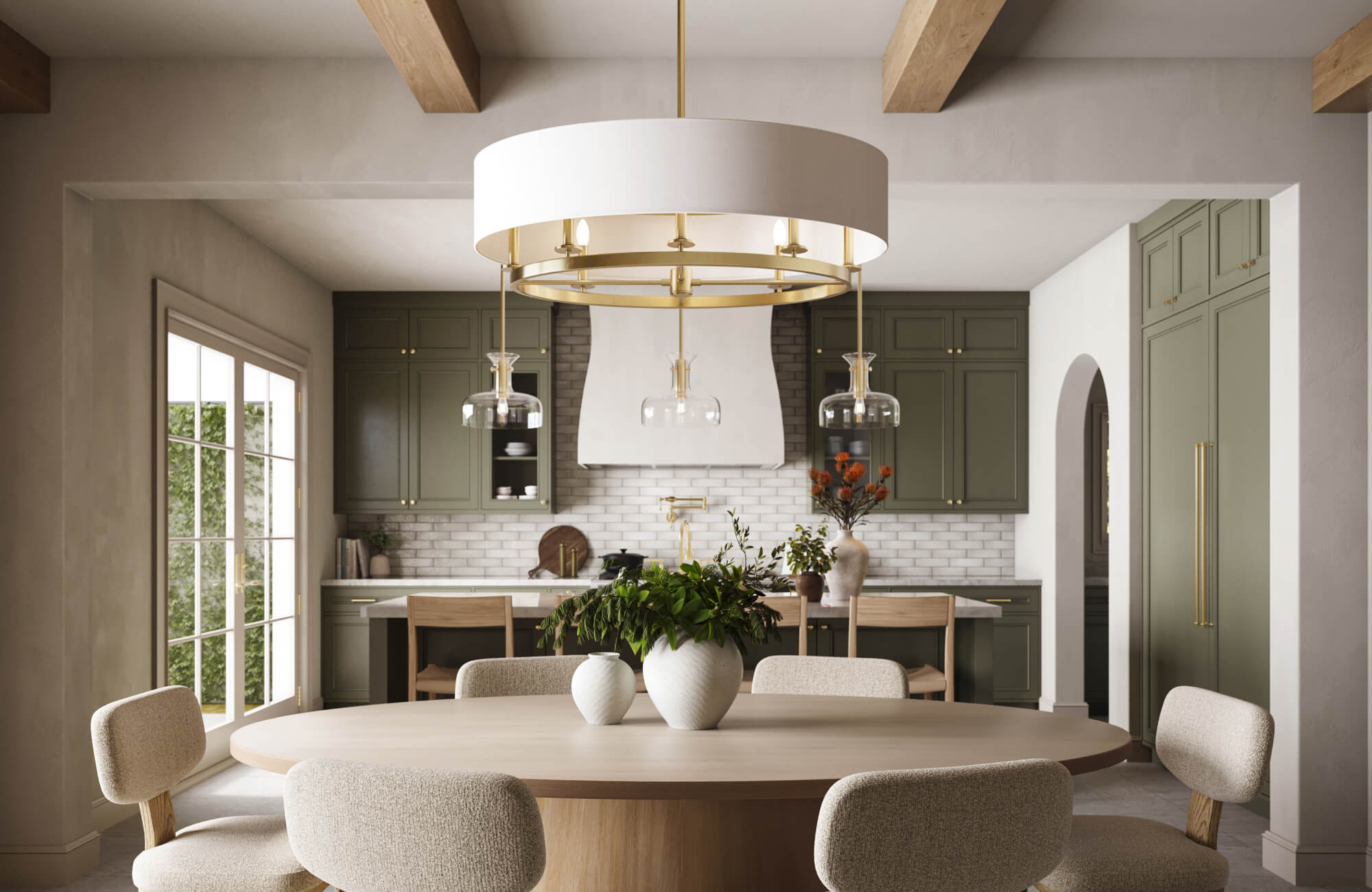 null Elegant dining area featuring a modern chandelier with a wide fabric drum shade and brass accents, illuminating a round wooden table set against sage green cabinetry and warm, natural textures.
