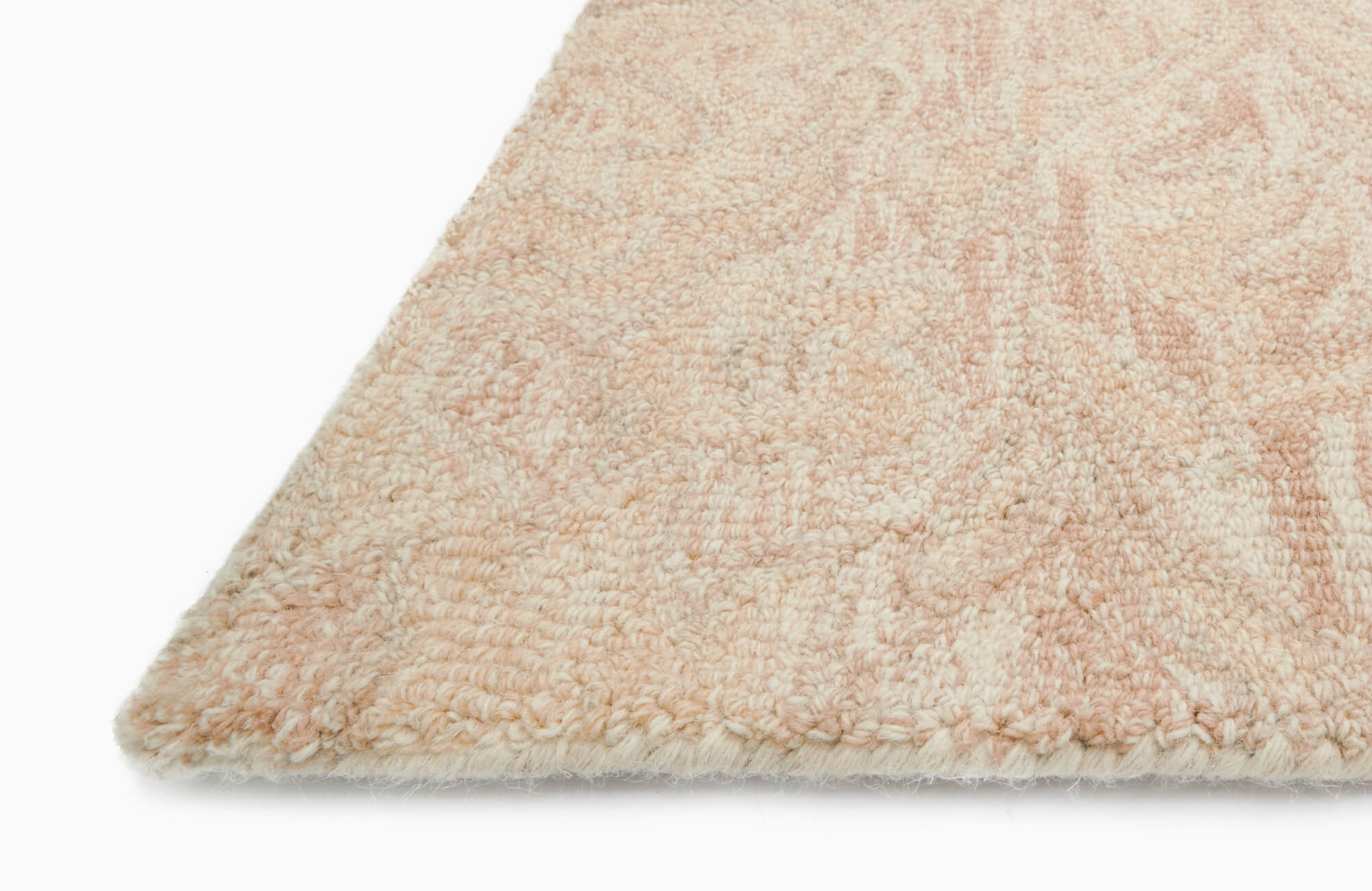 Plush, looped wool rug in soft beige and salmon pink with a subtle textured pattern, offering a cozy and elegant touch to any space.