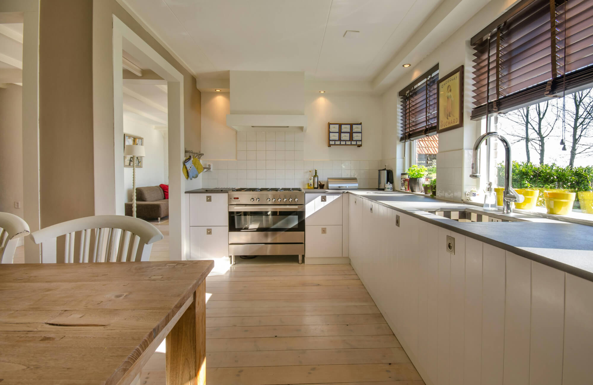 null Spacious kitchen with light wood flooring and open workspace showing how maintaining clean, dry surfaces helps protect wood floors from moisture and everyday use.