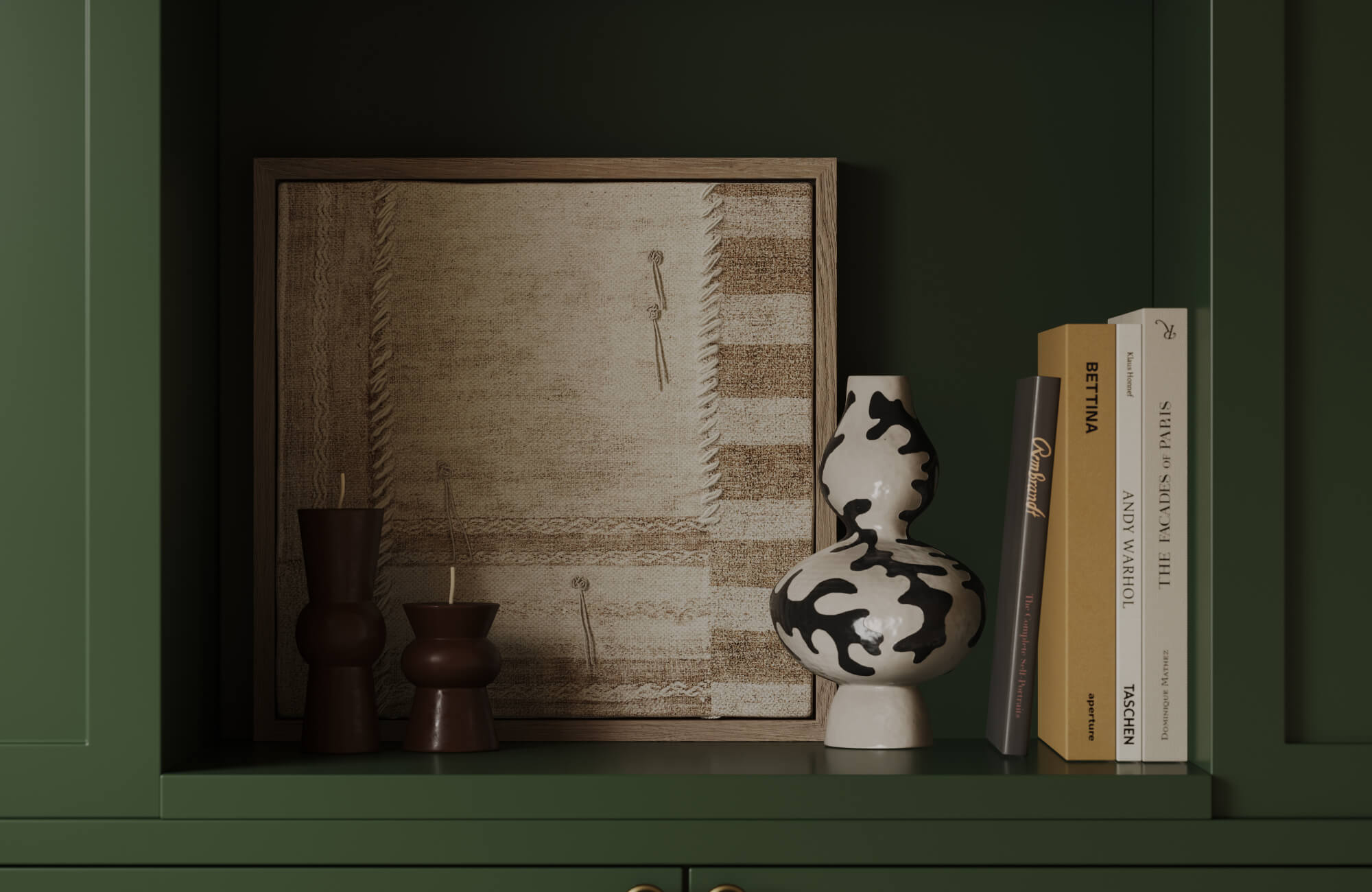 Neutral wall art in beige and tan fabric textures, paired with black-and-white ceramic and warm brown accents against a dark green built-in for contrast.