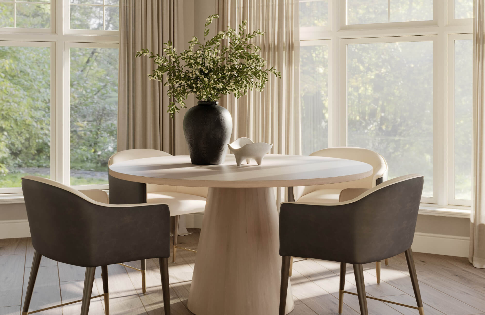 Black dining chairs paired with a pale round table and neutral textiles, using daylight and soft curtains to keep the space airy.