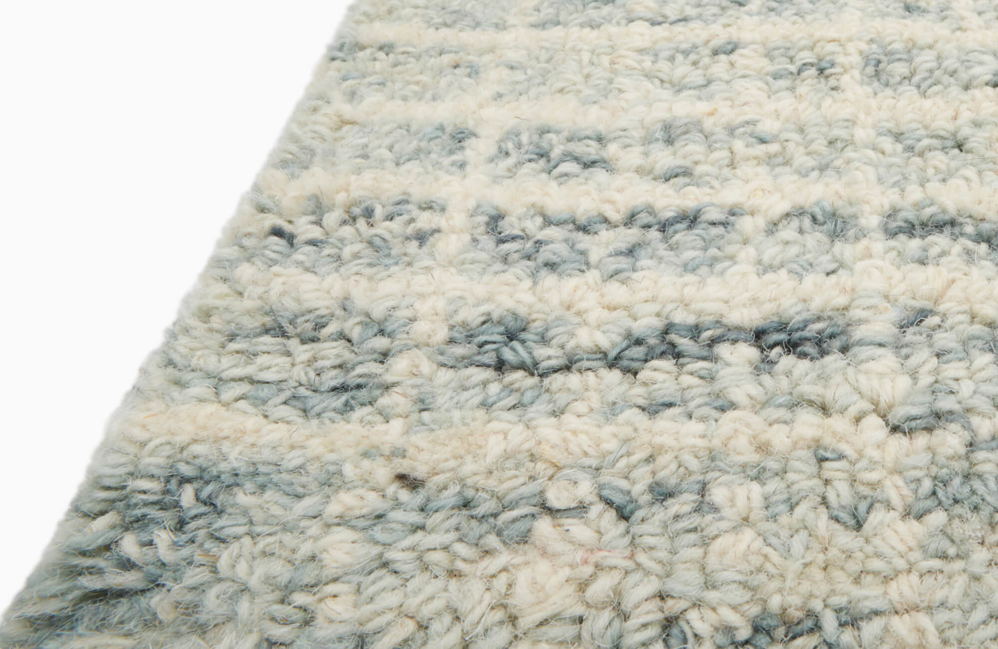 null Close-up of a plush wool rug with thick, looped texture in soft cream and blue tones.