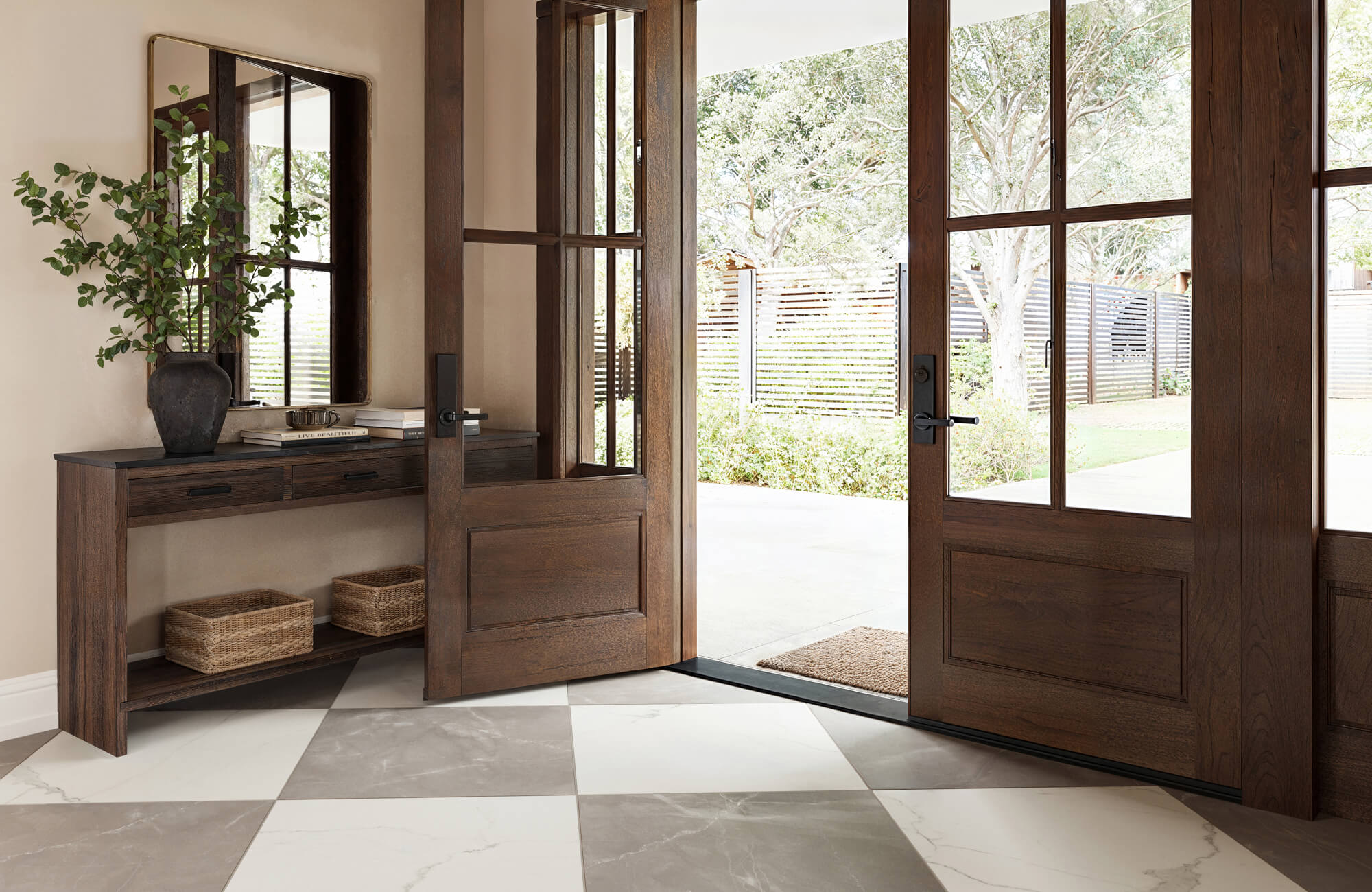 null Entryway with wood doors opening to checkerboard marble-look tile flooring, creating a bold transition from exterior to interior space.