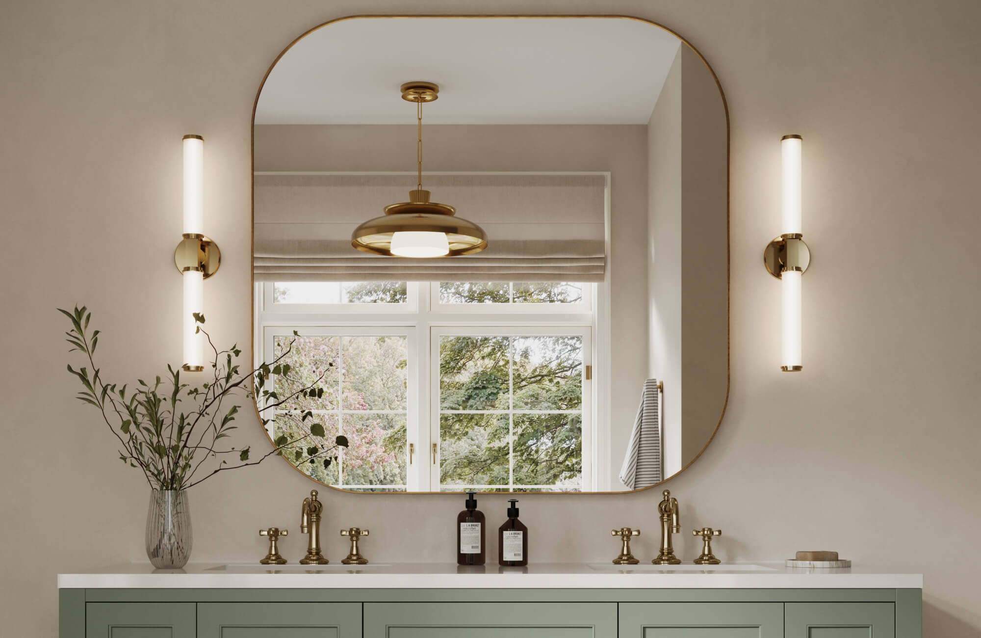 Fresh bathroom with a mint green double vanity, large, rounded-edge mirror, tubular brass sconces, and a modern brass pendant.