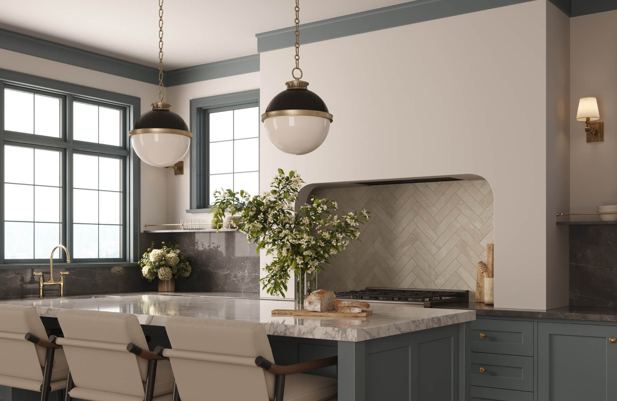 null Elegant kitchen with marble countertops, blue cabinetry, and two globe pendant lights hanging above an island with cream chairs.