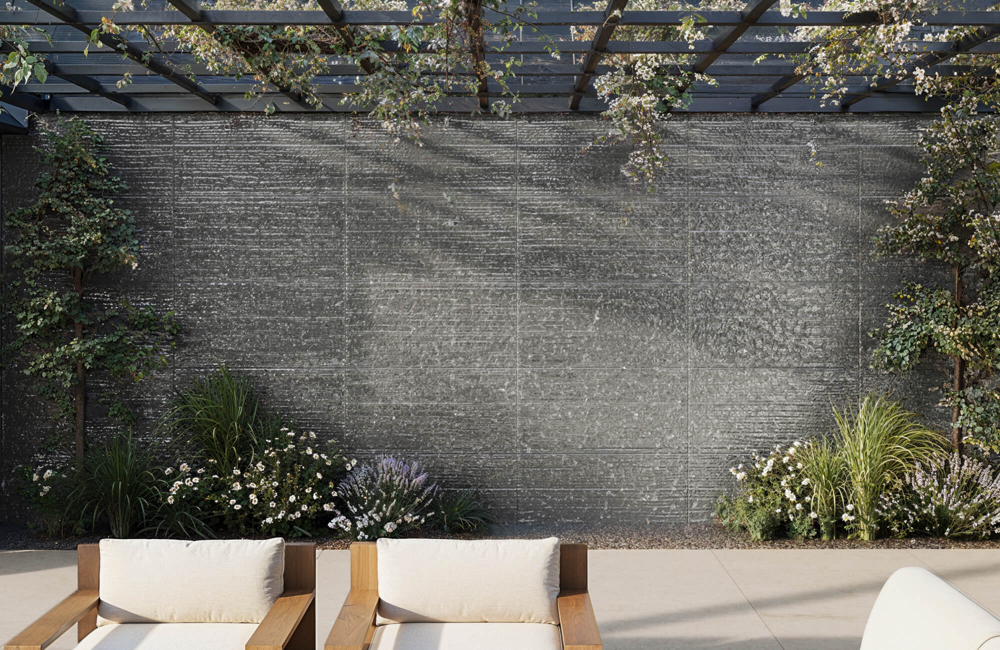 Textured charcoal porcelain tile wall creates a striking focal point in this serene outdoor lounge setting.