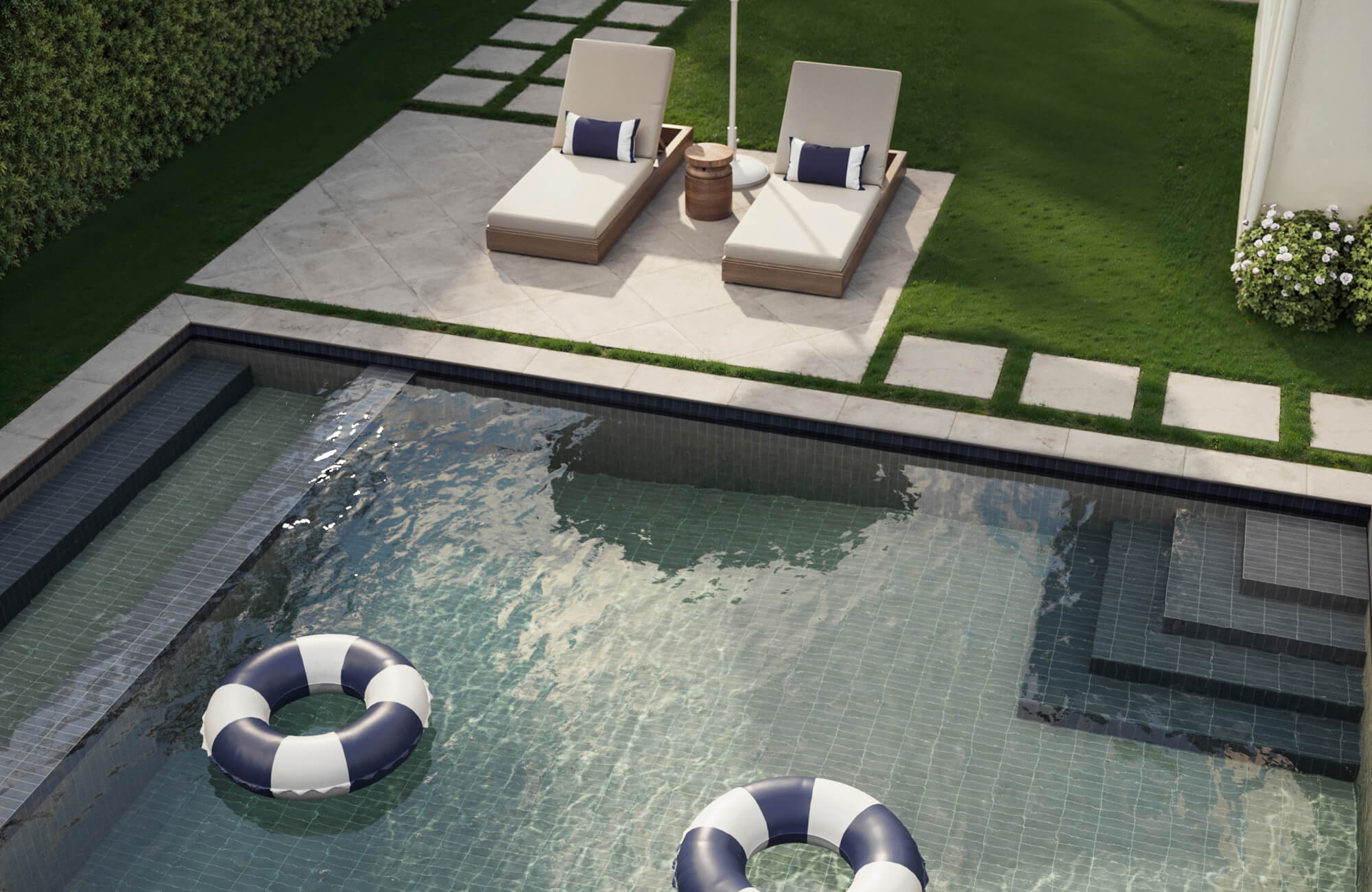 null Chic outdoor pool with sleek dark gray pool tile, complemented by modern lounge chairs and lush greenery for a sophisticated resort-style ambiance.