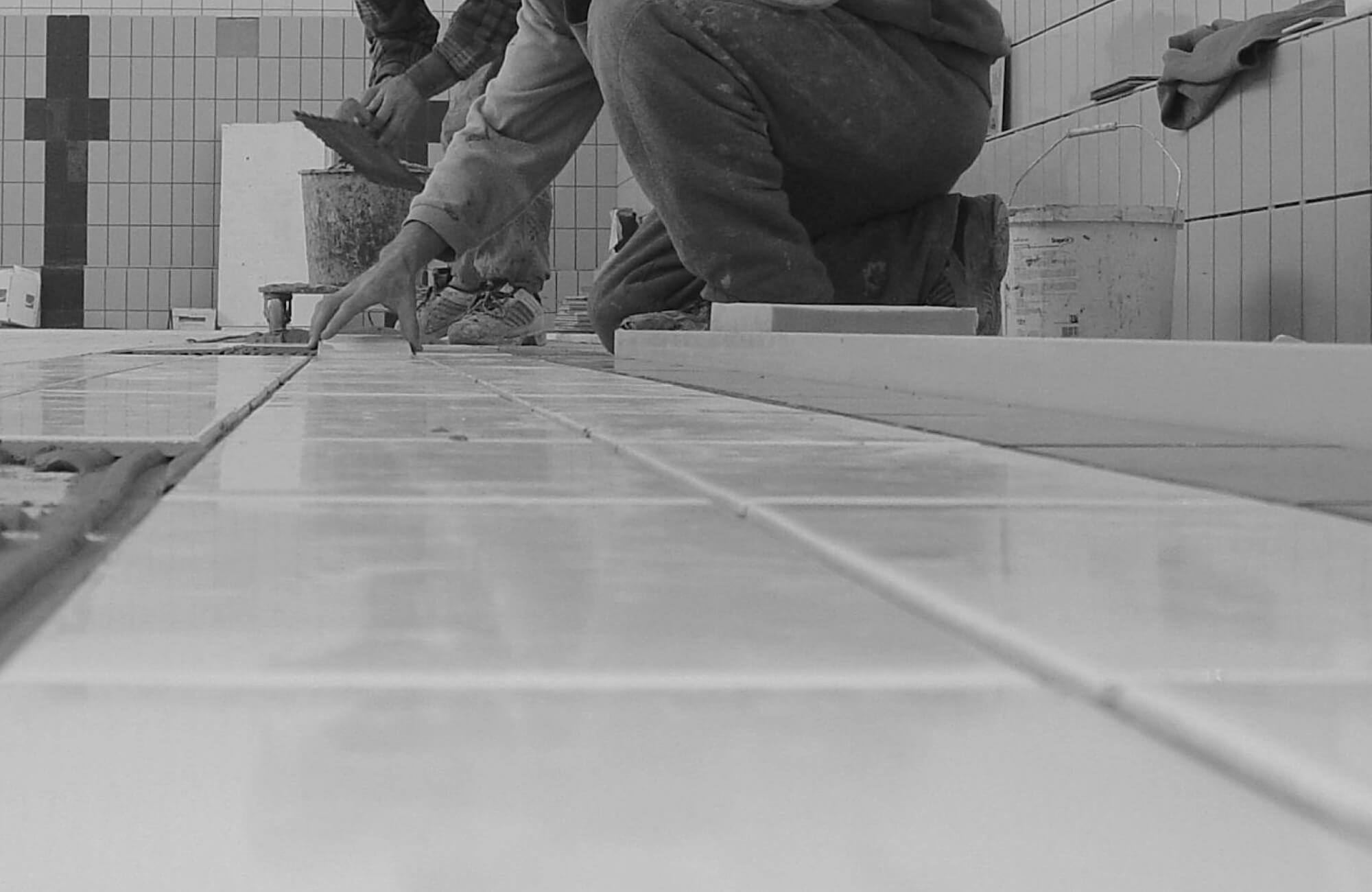 null Close-up of skilled workers installing glossy pool tile, carefully aligning each piece to ensure precision and durability in the pool’s foundation.