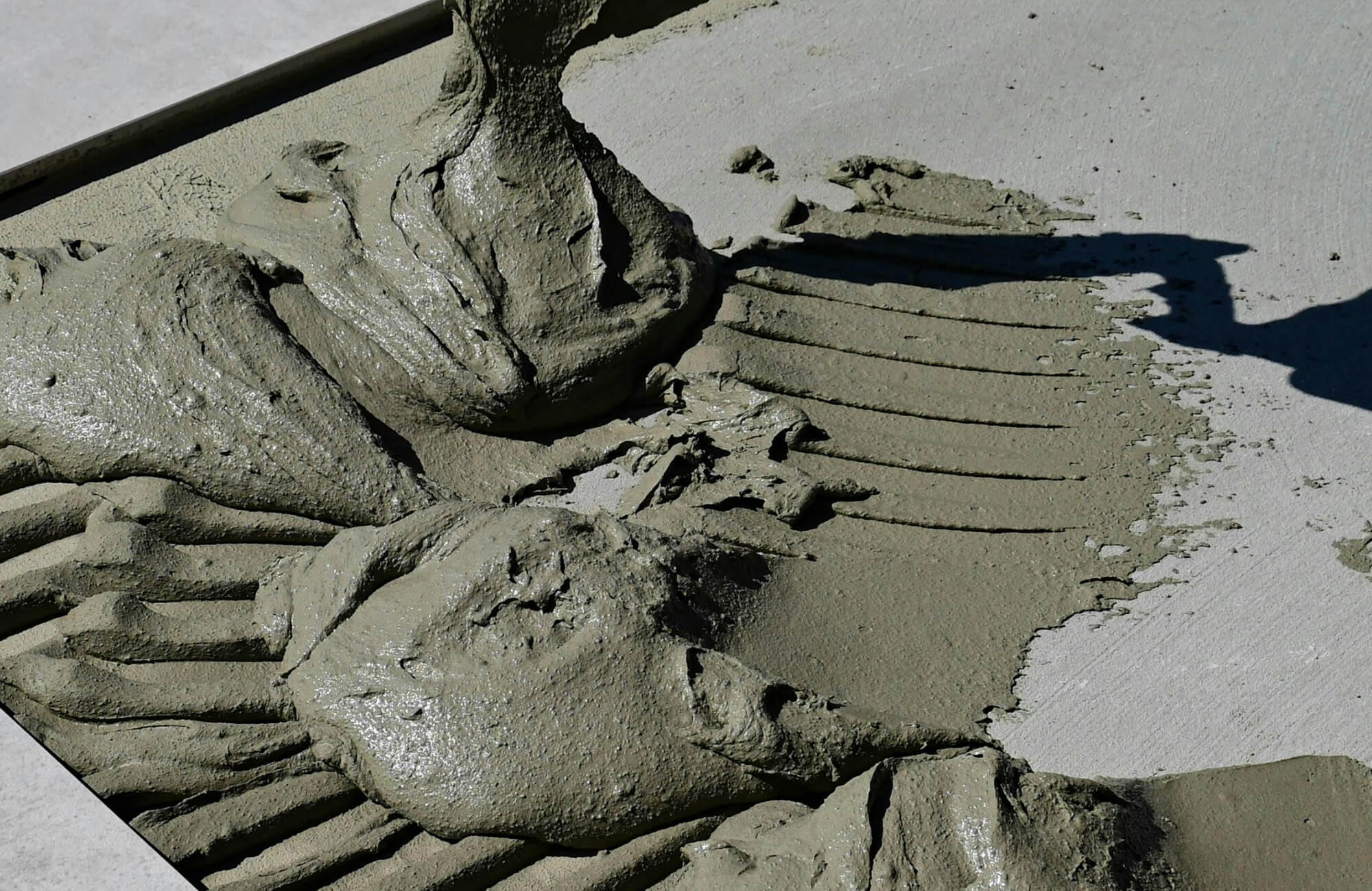 null Fresh cement mortar being spread across a surface, creating a strong foundation layer essential for secure and durable pool tile installation.