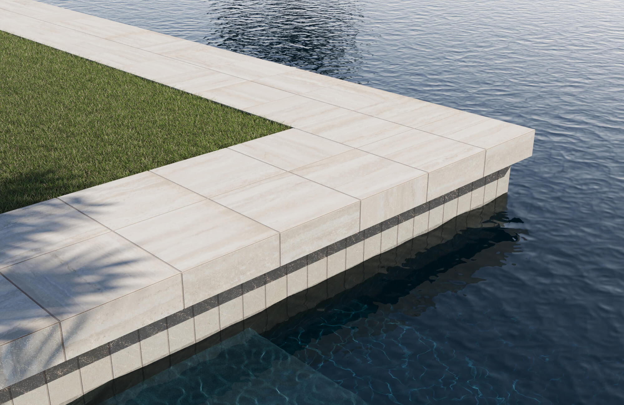 null Contemporary poolside with beige stone pool tile and sleek coping, blending seamlessly with lush green grass and deep blue water for a refined outdoor design.