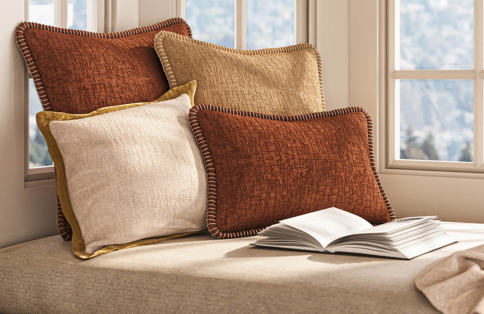 Layered rust, beige, and cream decorative pillows with textured fabric on a neutral upholstered bench.