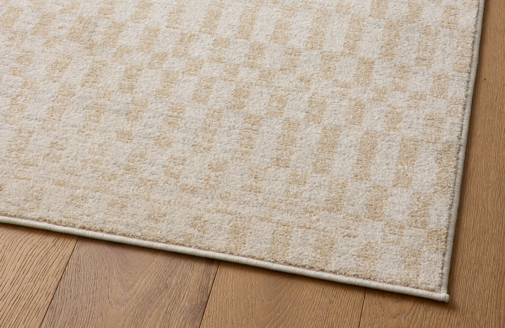 null Elegant area rug with a subtle geometric pattern in warm beige tones, adding texture and sophistication to a natural wood floor.