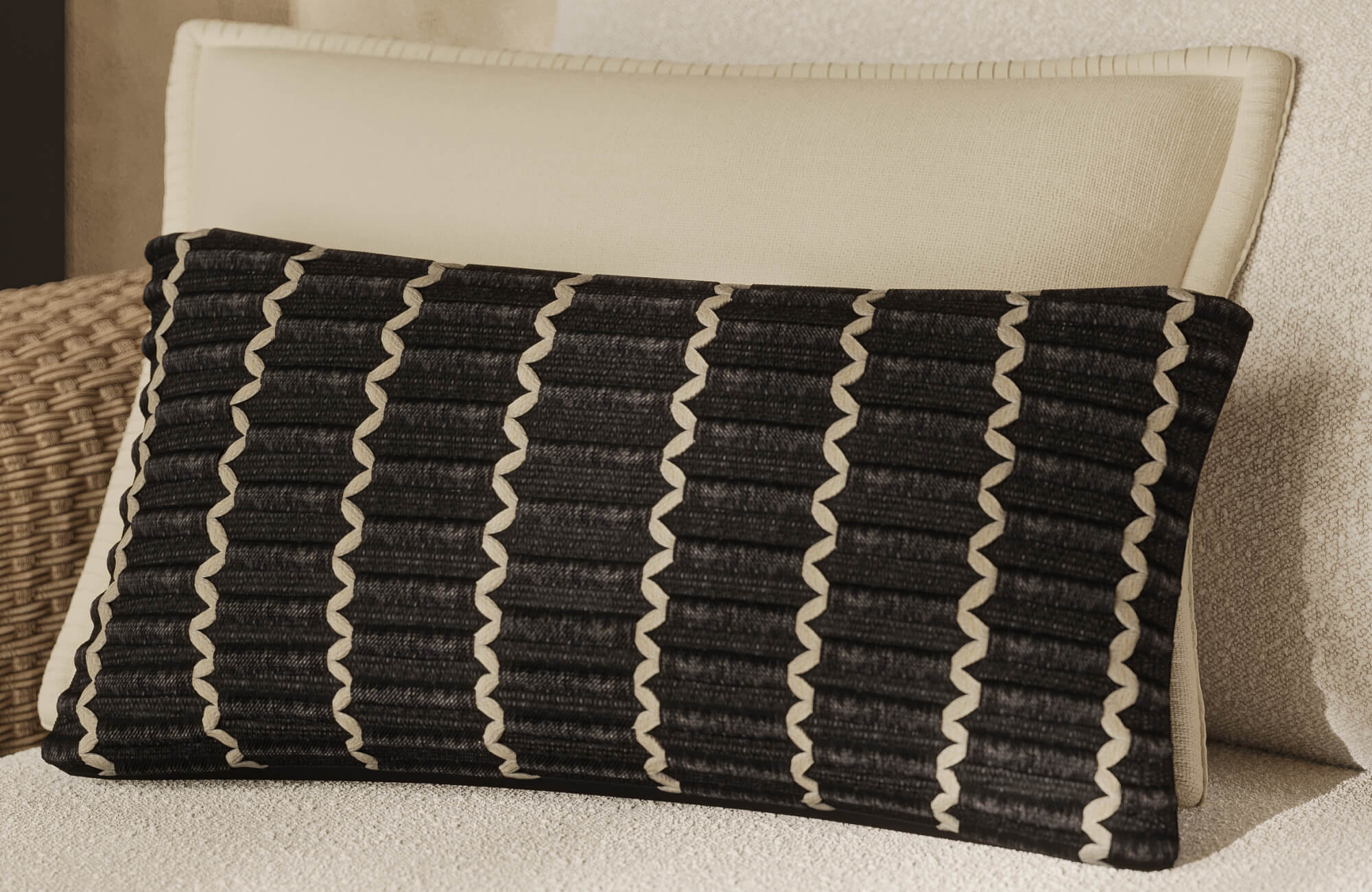 null A black textured lumbar accent rests against a cream outdoor cushion, showcasing pronounced woven detailing and contrasting trim in a sheltered seating area.