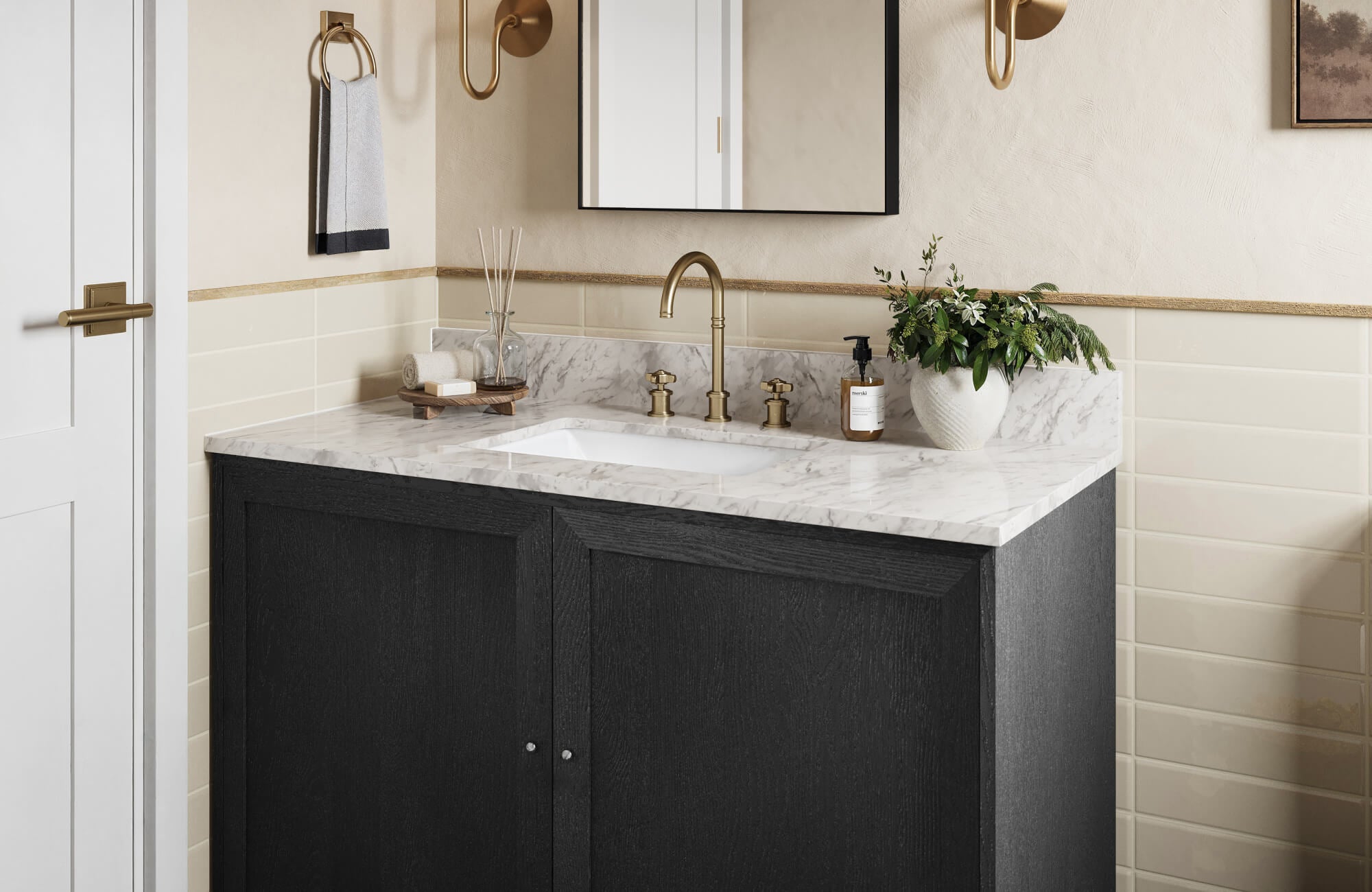 Modern vanity with dark wood cabinetry and marble countertop, paired with brass fittings and soft beige wall tile for a warm, classic look.