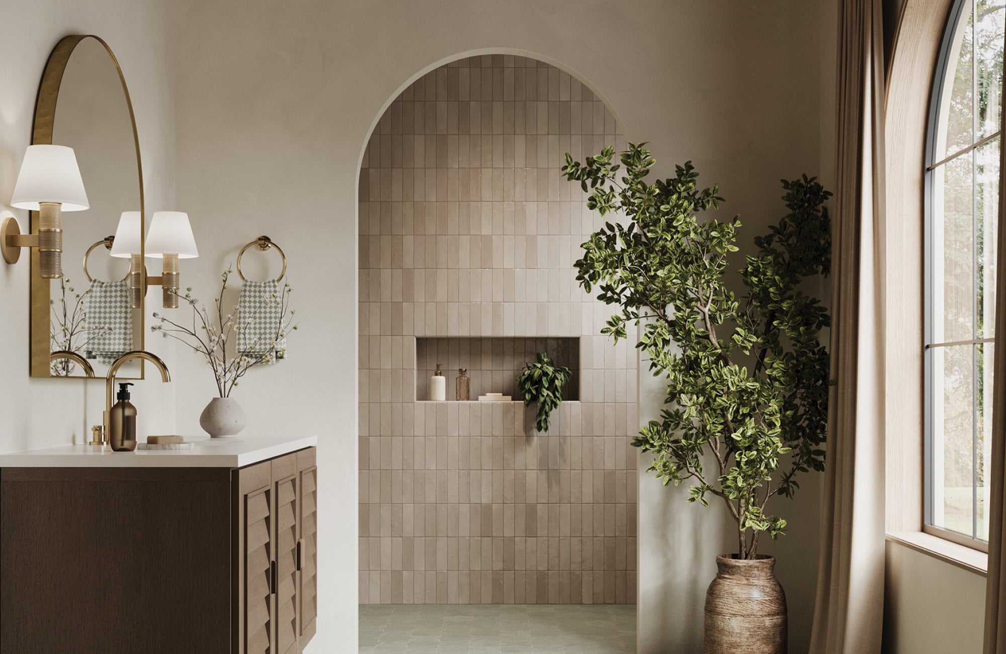 Serene bathroom with an arched brass mirror reflecting natural light from a nearby window.