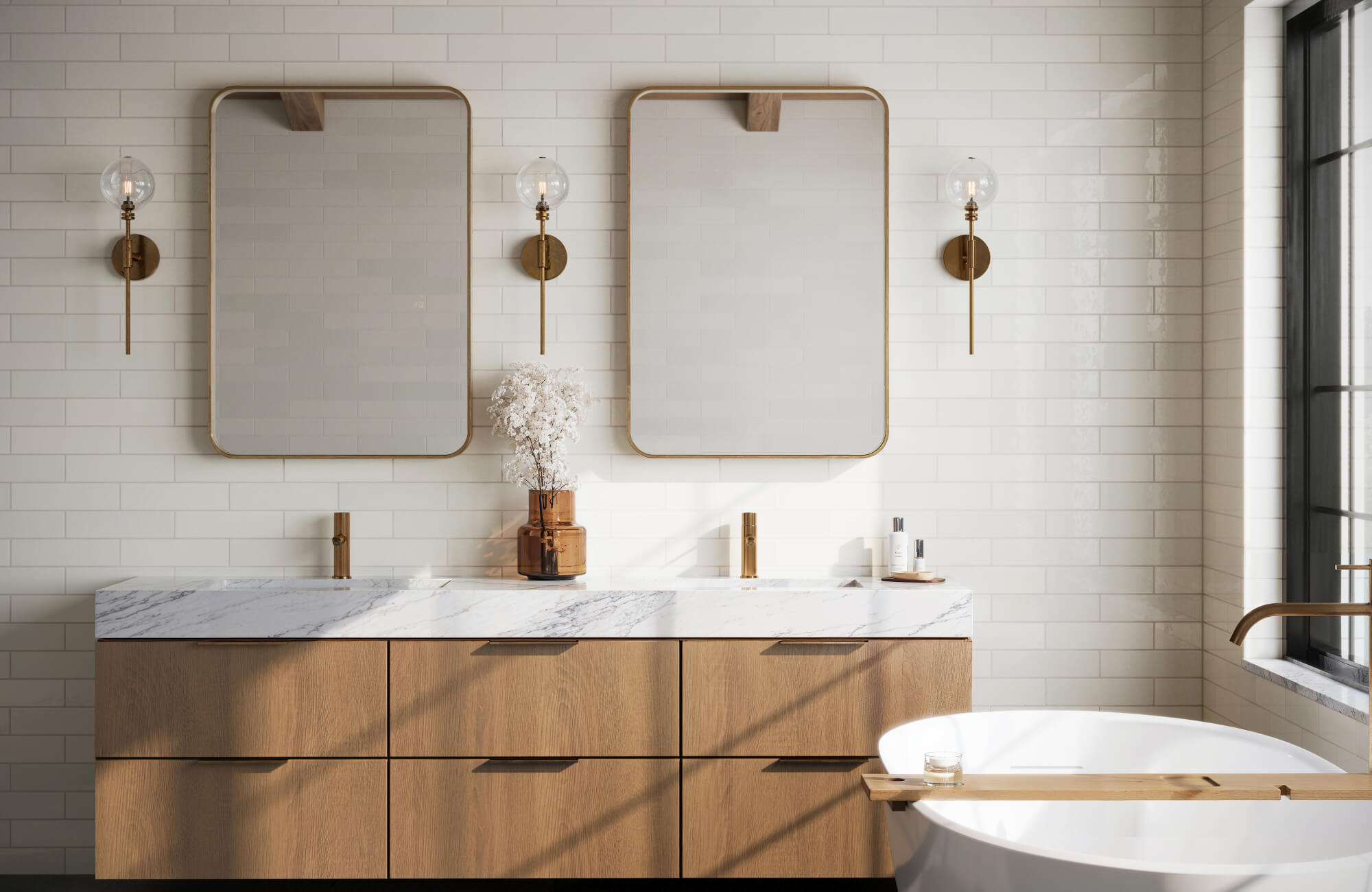 Bright bathroom featuring glossy white subway tiles, natural wood cabinetry, and marble countertops, accented by warm brass fixtures and soft lighting for a clean, modern aesthetic.