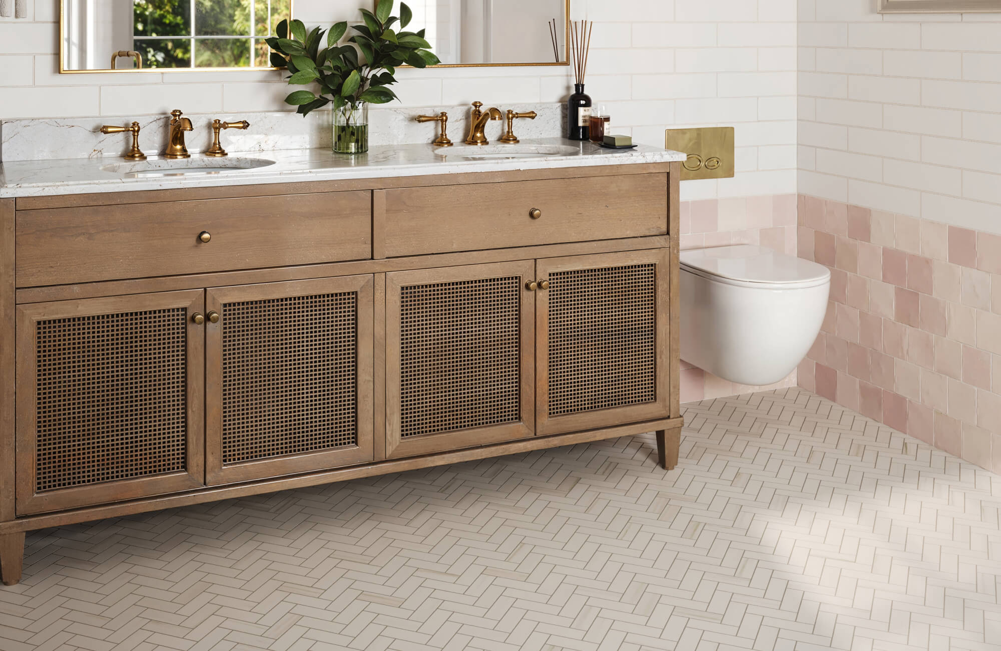 null Stylish bathroom with a wooden vanity, brass fixtures, and elegant herringbone floor tile adding a refined, timeless touch.