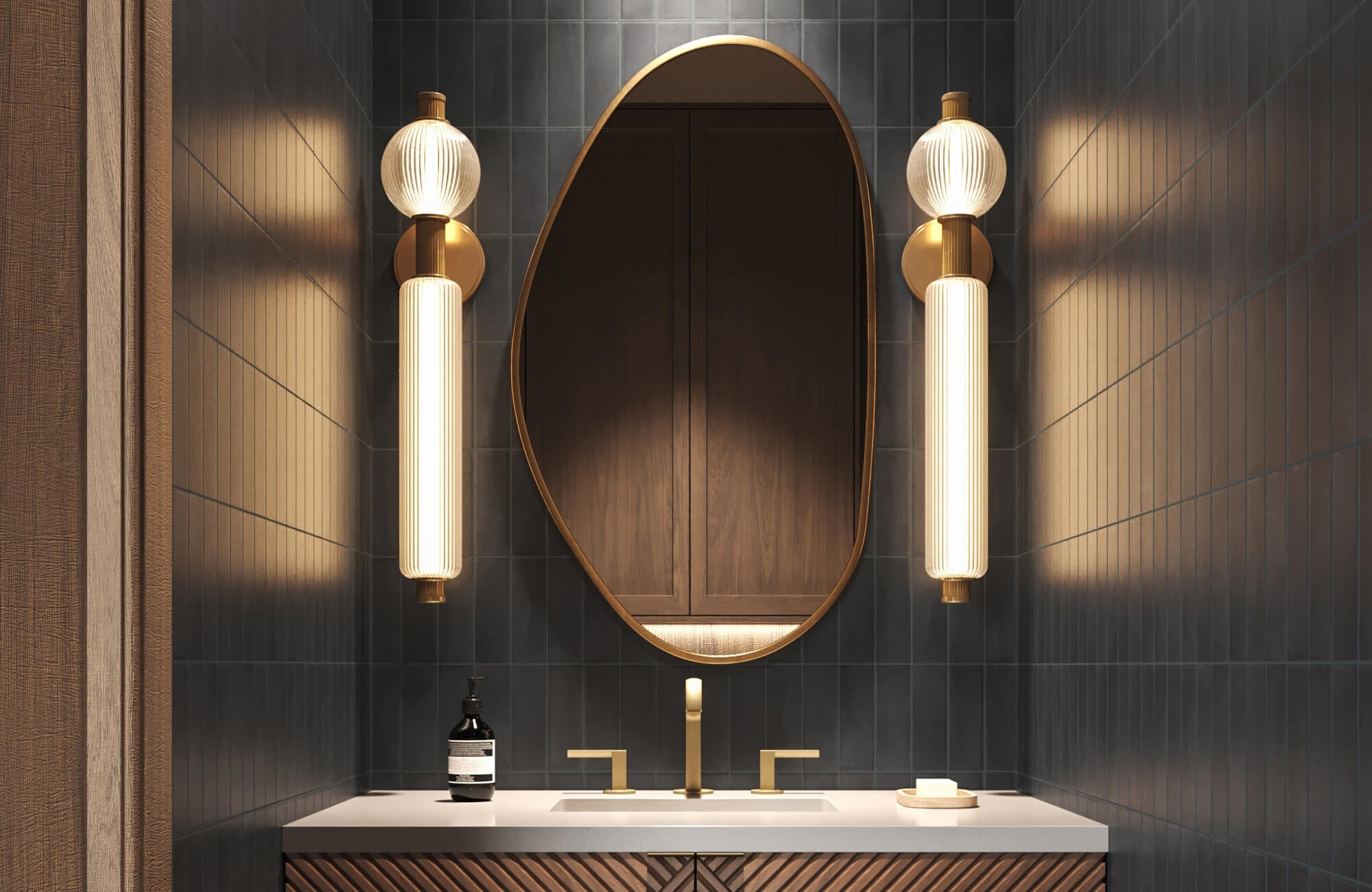 Moody bathroom with deep navy tile walls, sculptural lighting sconces, and an asymmetrical framed mirror above a wood-textured vanity.