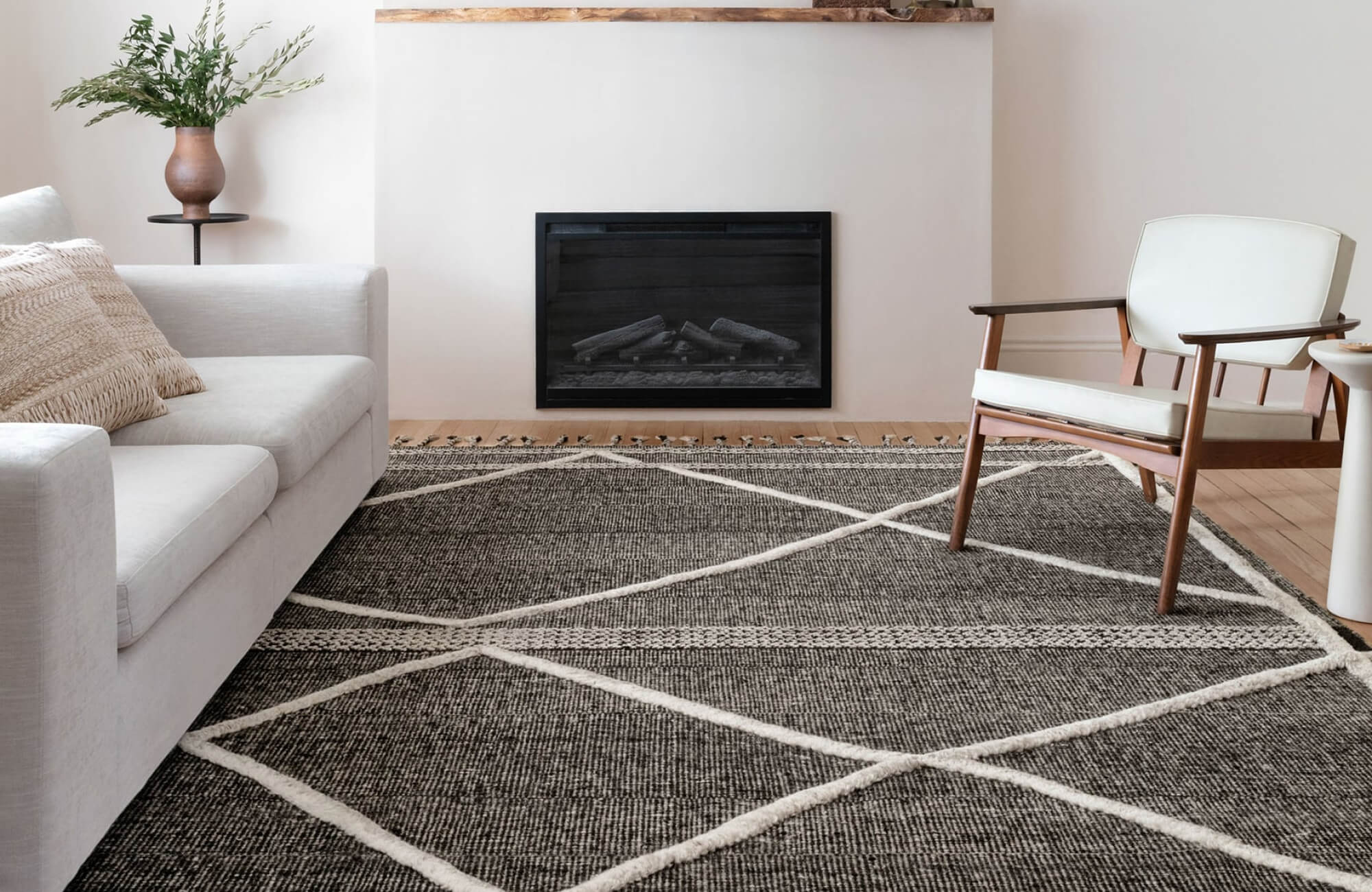null Modern living room with a dark textured rug featuring bold ivory geometric lines, paired with neutral furniture and a sleek fireplace.