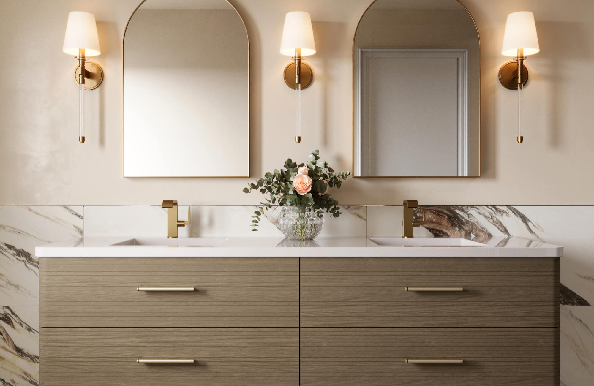 Dual-sink vanity with gold faucets and soft arch mirrors, accented by elegant brass and glass sconces.