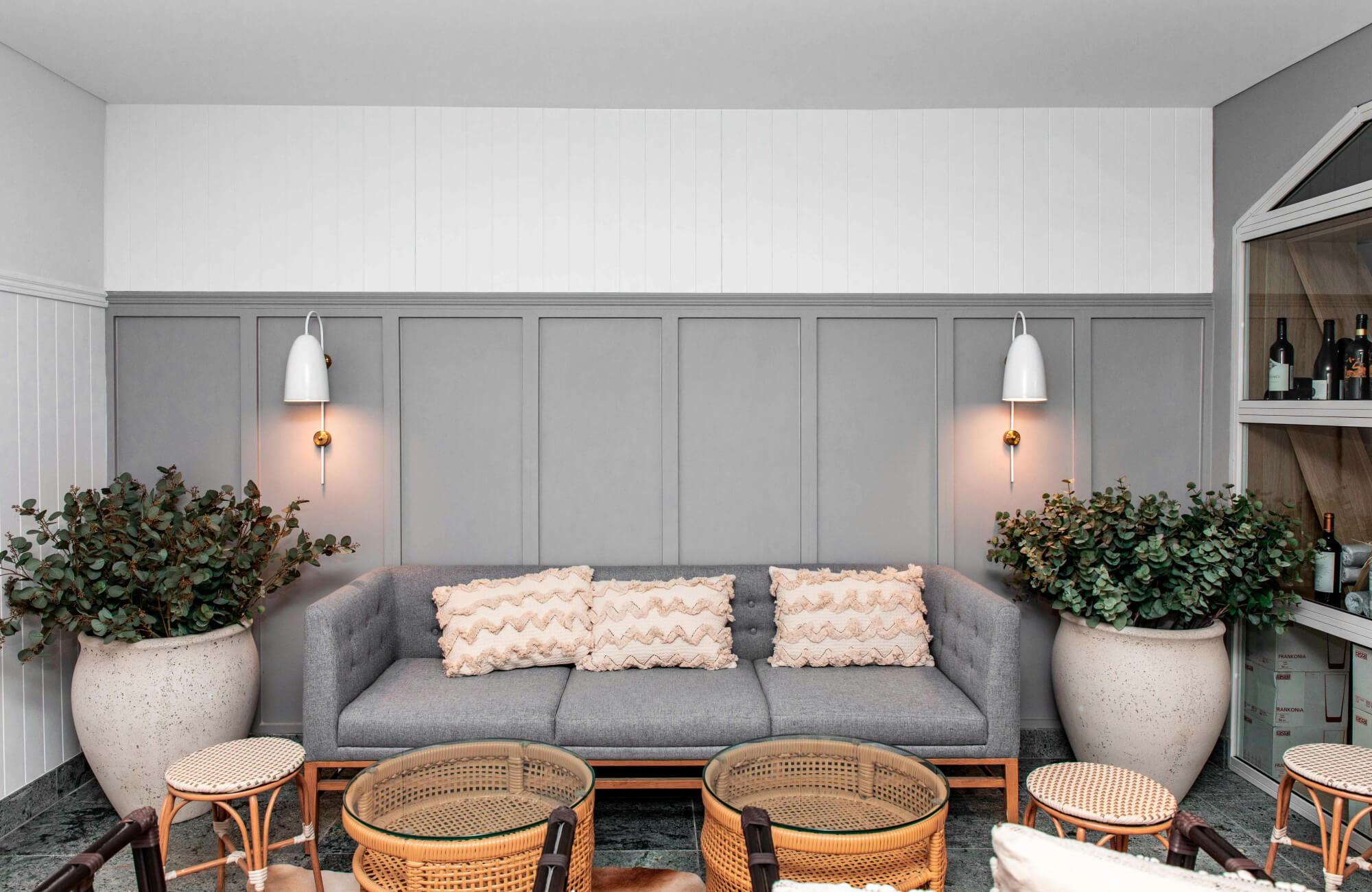Wall-mounted sconces frame a sofa, providing vertical light and visual balance without the need for overhead fixtures.