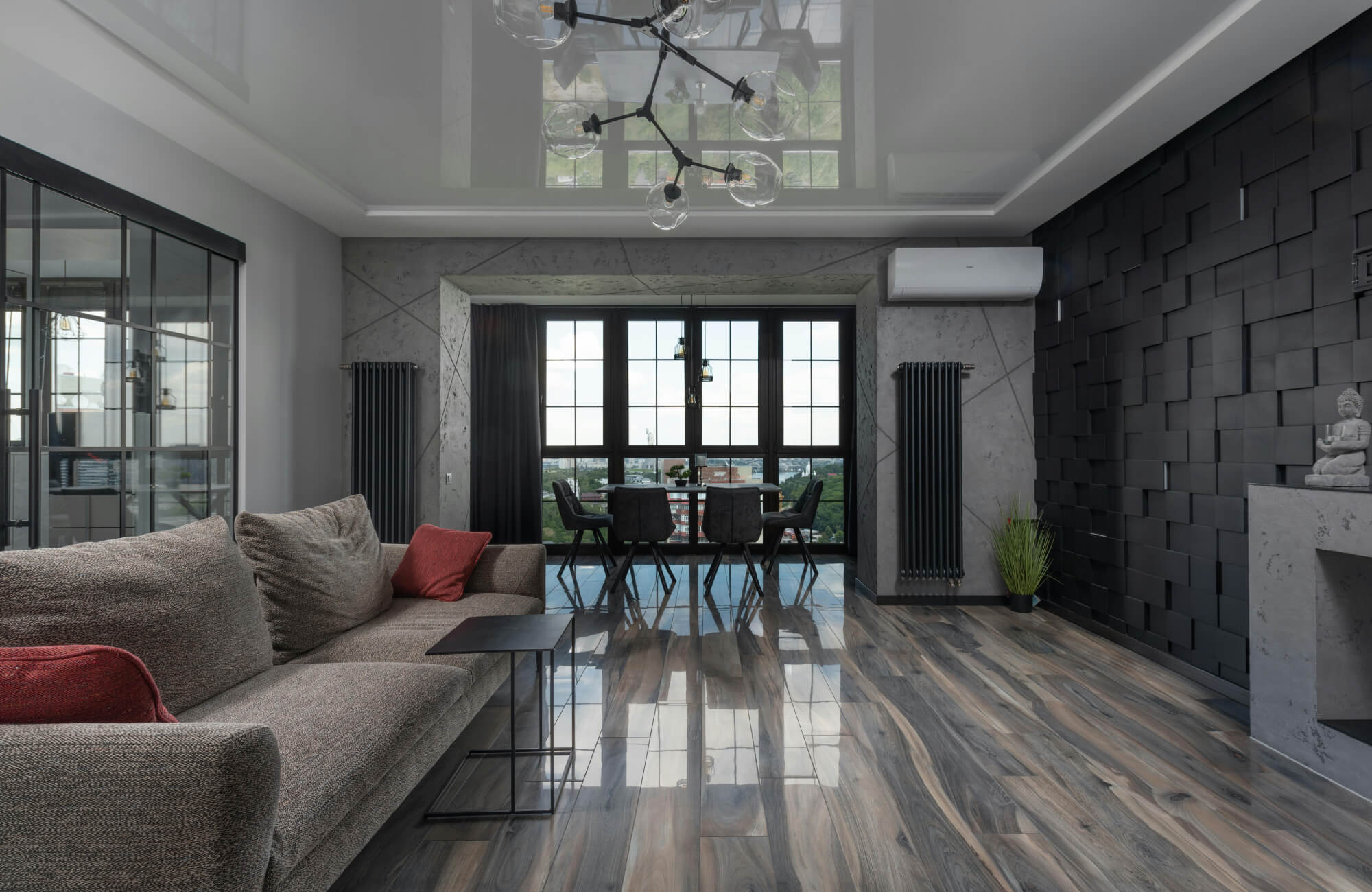 Modern interior featuring a bold black accent wall, panoramic dining nook, and layered lighting with natural light and a central glass-bulb chandelier.