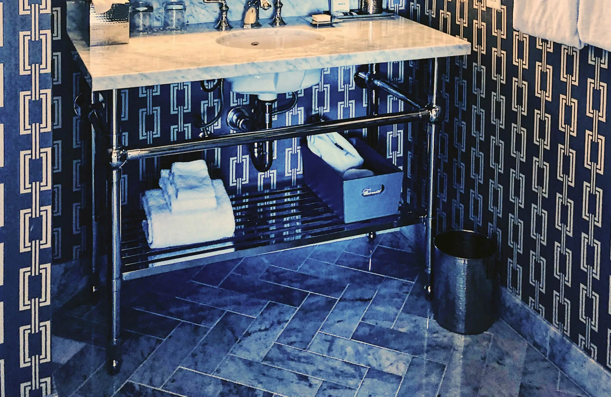 Chic bathroom with marble herringbone tile flooring that adds timeless texture and refined sophistication to the vanity space.