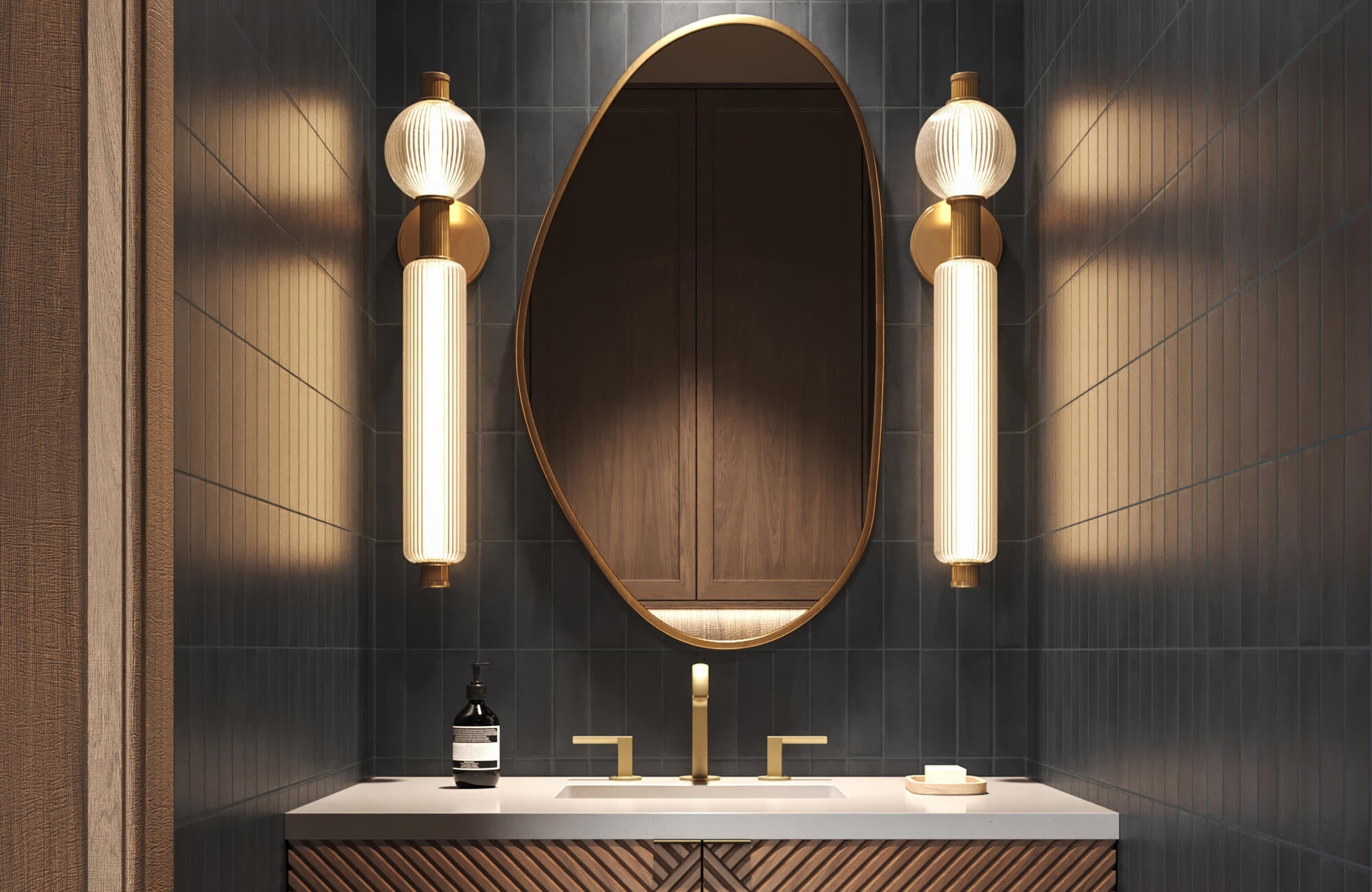 null Luxurious bathroom with deep charcoal vertical tiles, sculptural lighting, and brushed gold fixtures beneath an oval mirror.