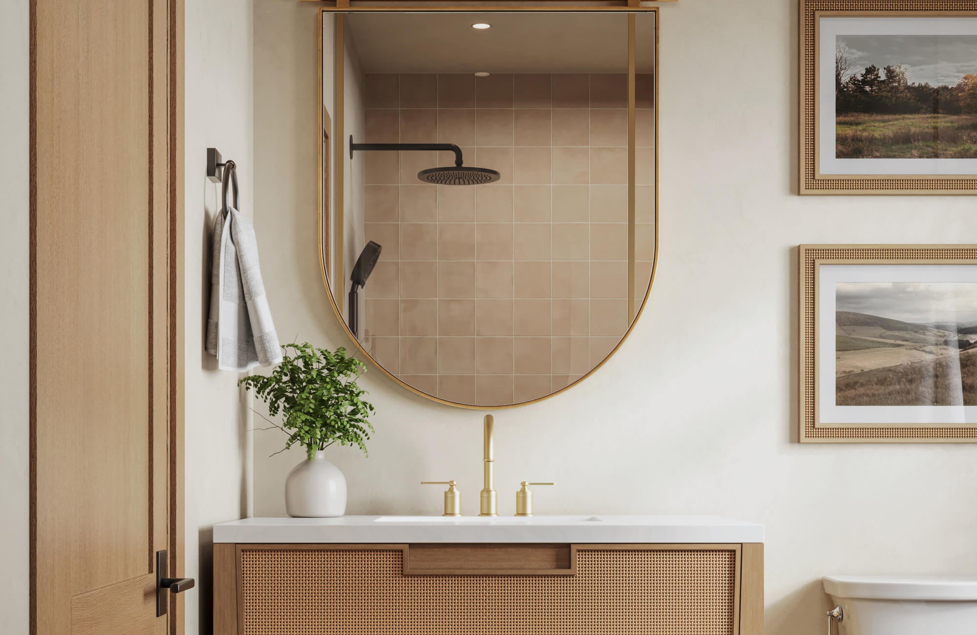 null Serene bathroom with sandy beige shower tiles, cane-front vanity, and brushed gold fixtures under a rounded mirror.