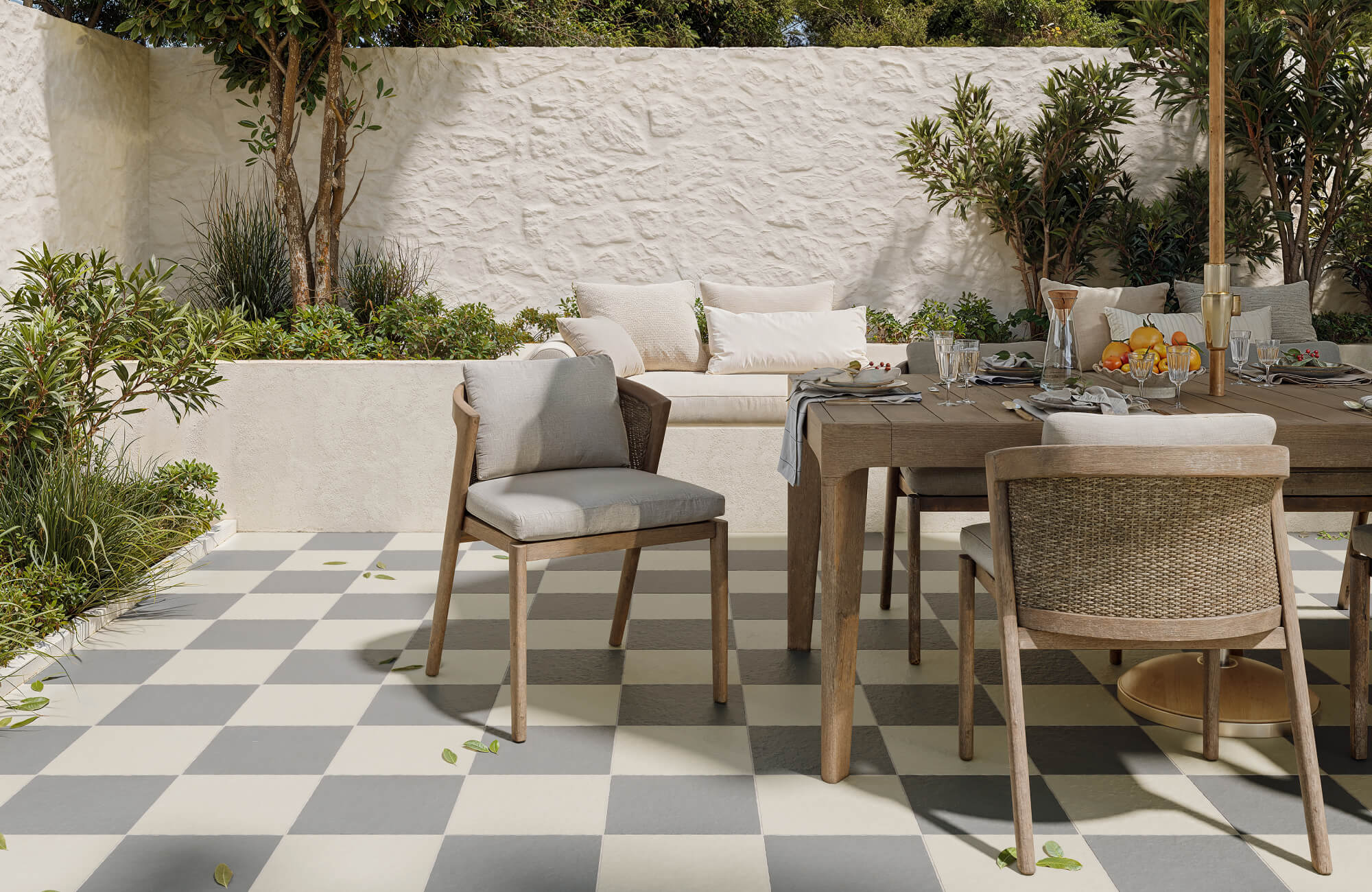 null Elegant interior with a grand curved staircase, checkerboard marble tiles in taupe and beige, and cozy earth-toned lounge chairs beneath an indoor tree.