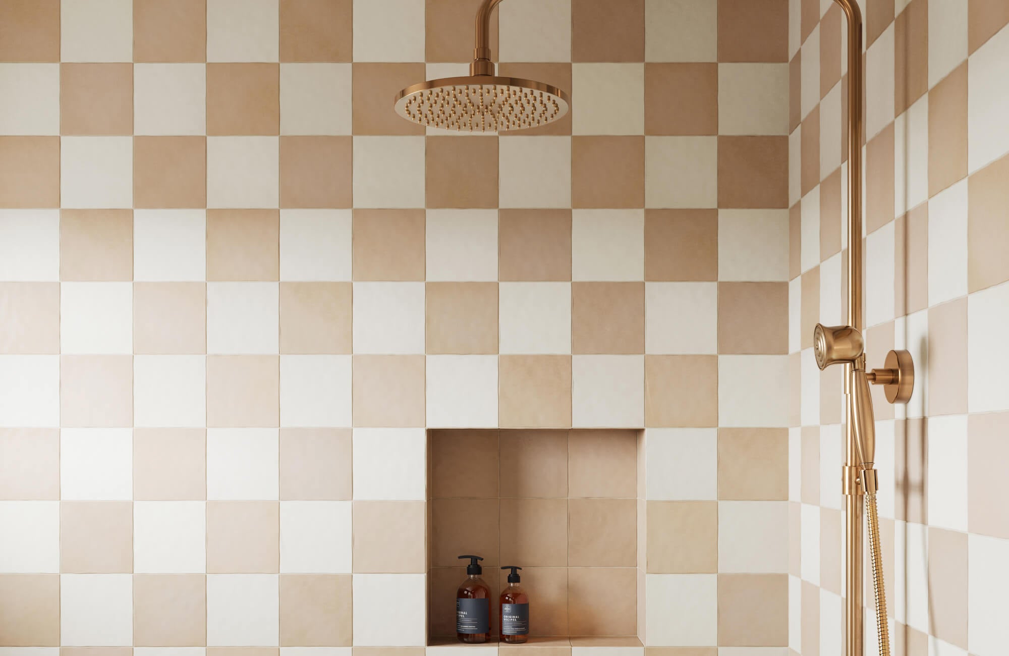 null Modern shower with blush and cream checkerboard tiles, gold fixtures, and a built-in niche holding amber-toned bottles.