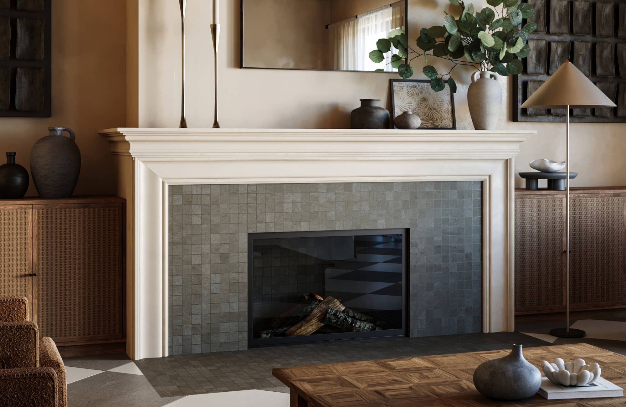 A contemporary fireplace with gray tiled surround and a traditional white mantle, paired with natural wood textures, ceramic vases, and soft greenery for a calm living space.