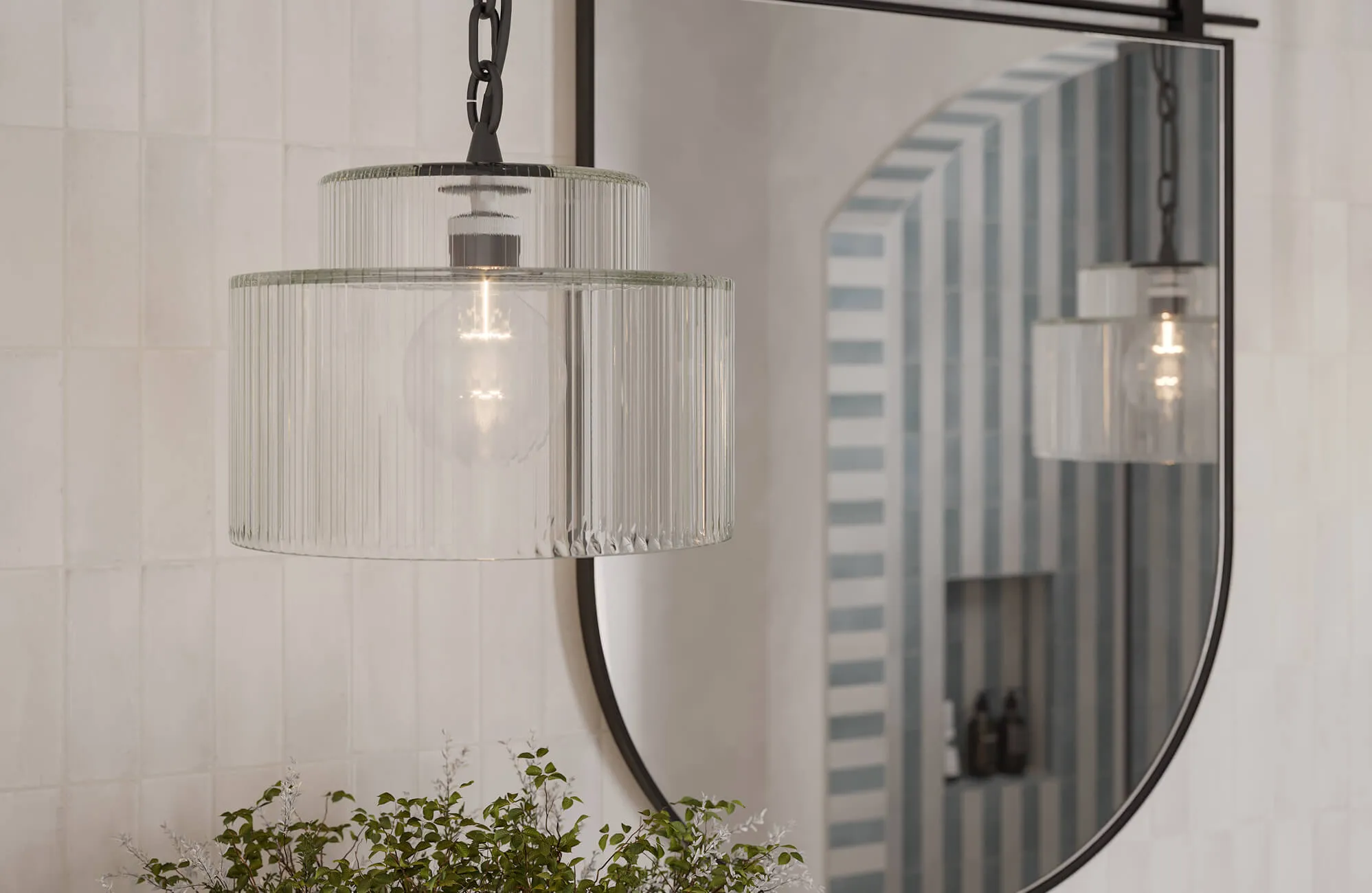 Elegant bathroom mirror paired with a ribbed glass pendant light fixture, creating a refined balance of modern illumination and timeless design.