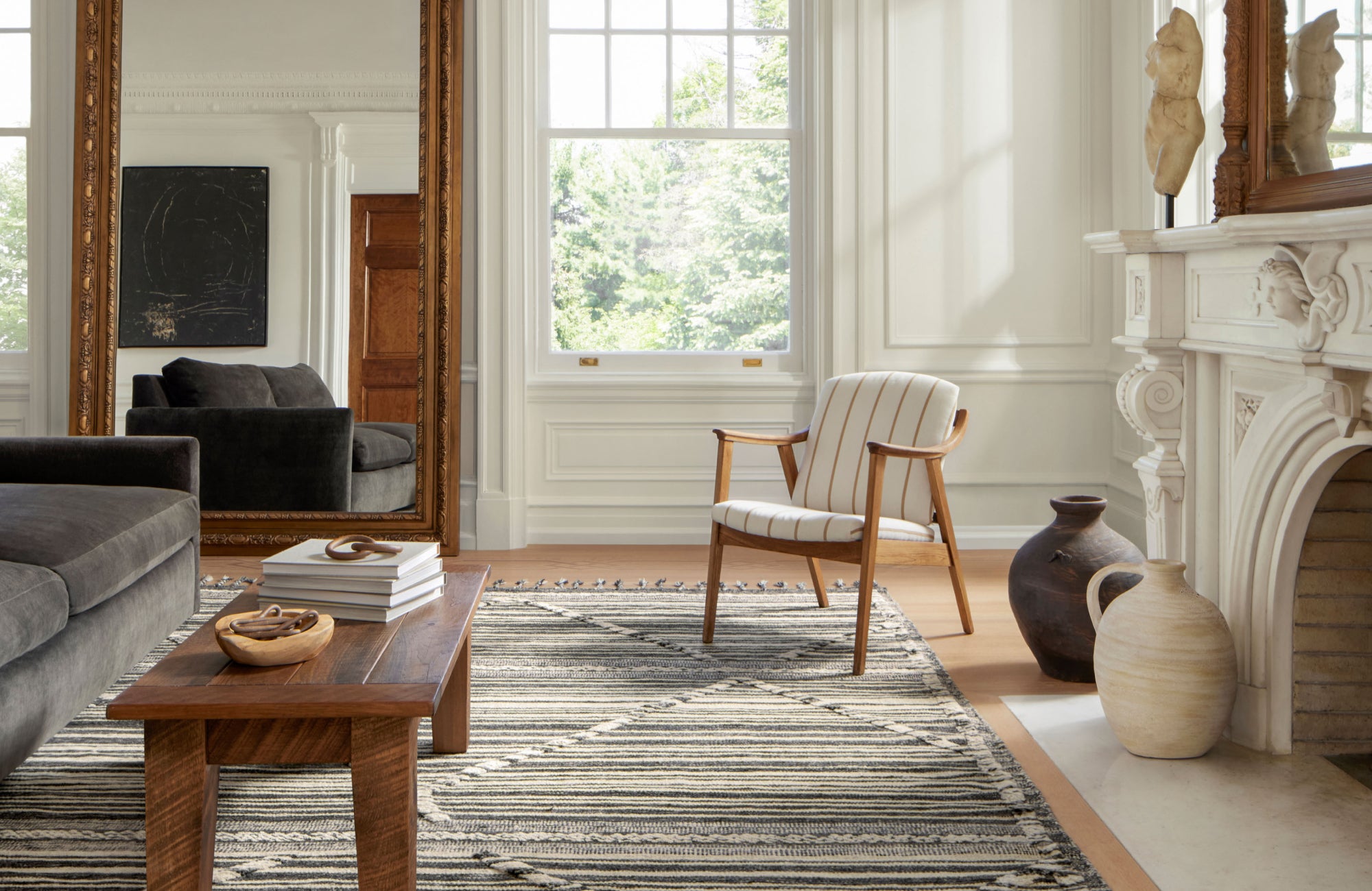 null Elegant living room with a striped flatweave rug and natural light, showing layered design in an indoor setting.