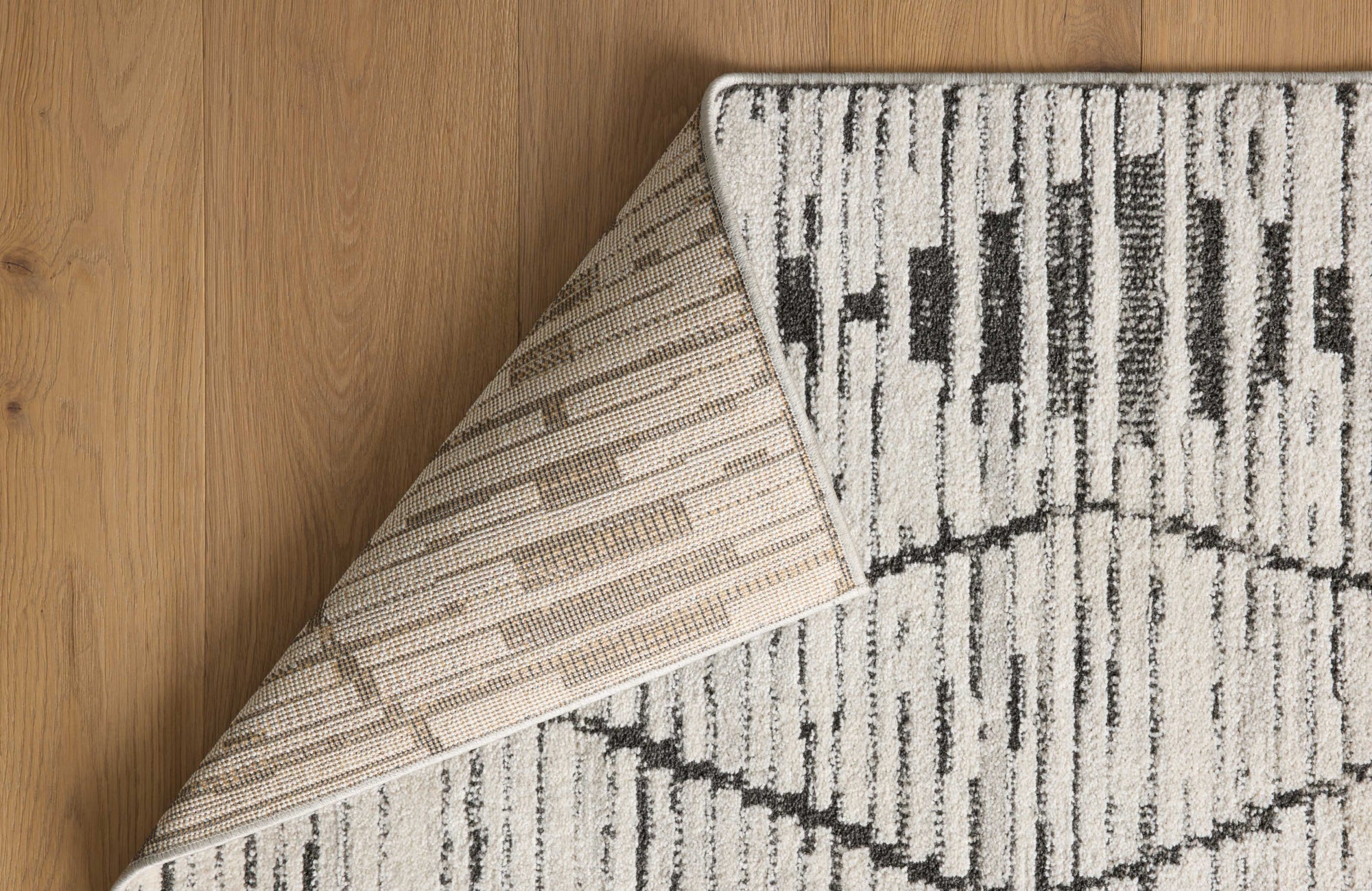 null Close-up of a rug corner showing synthetic backing and simple weave, ideal for indoor-outdoor flexibility.