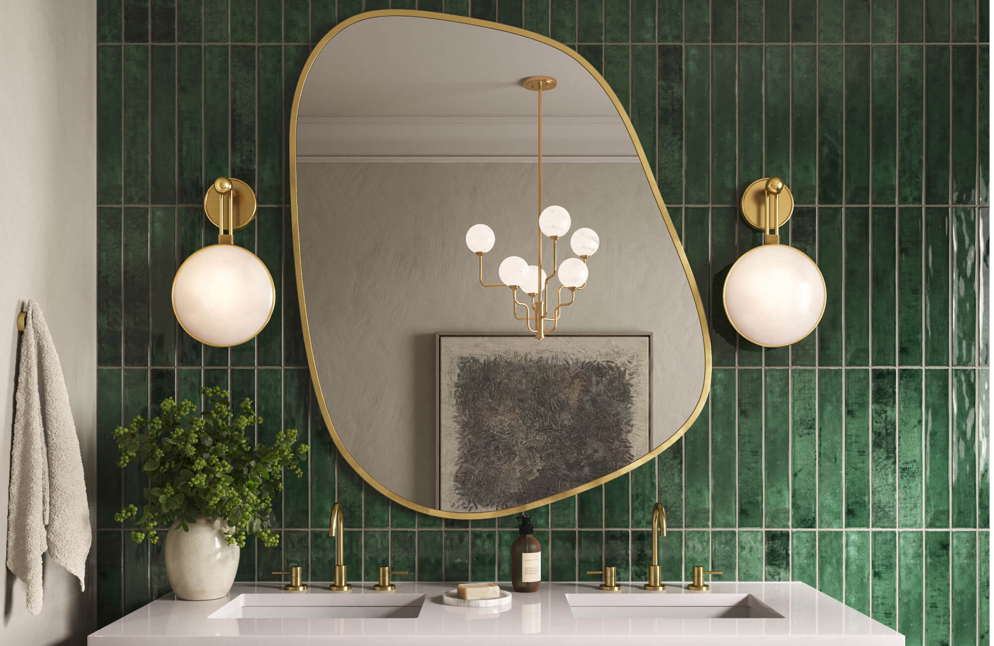 null Asymmetrical gold-framed mirror above a double vanity with gold fixtures, flanked by globe wall sconces against glossy emerald green tile.