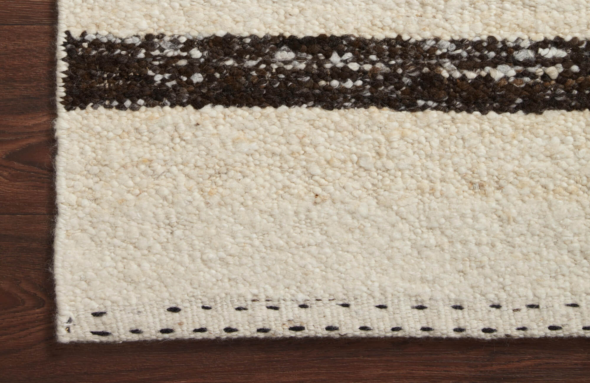 Plush ivory 9x12 rug with handwoven black accents, offering a cozy texture and timeless, artisanal charm.