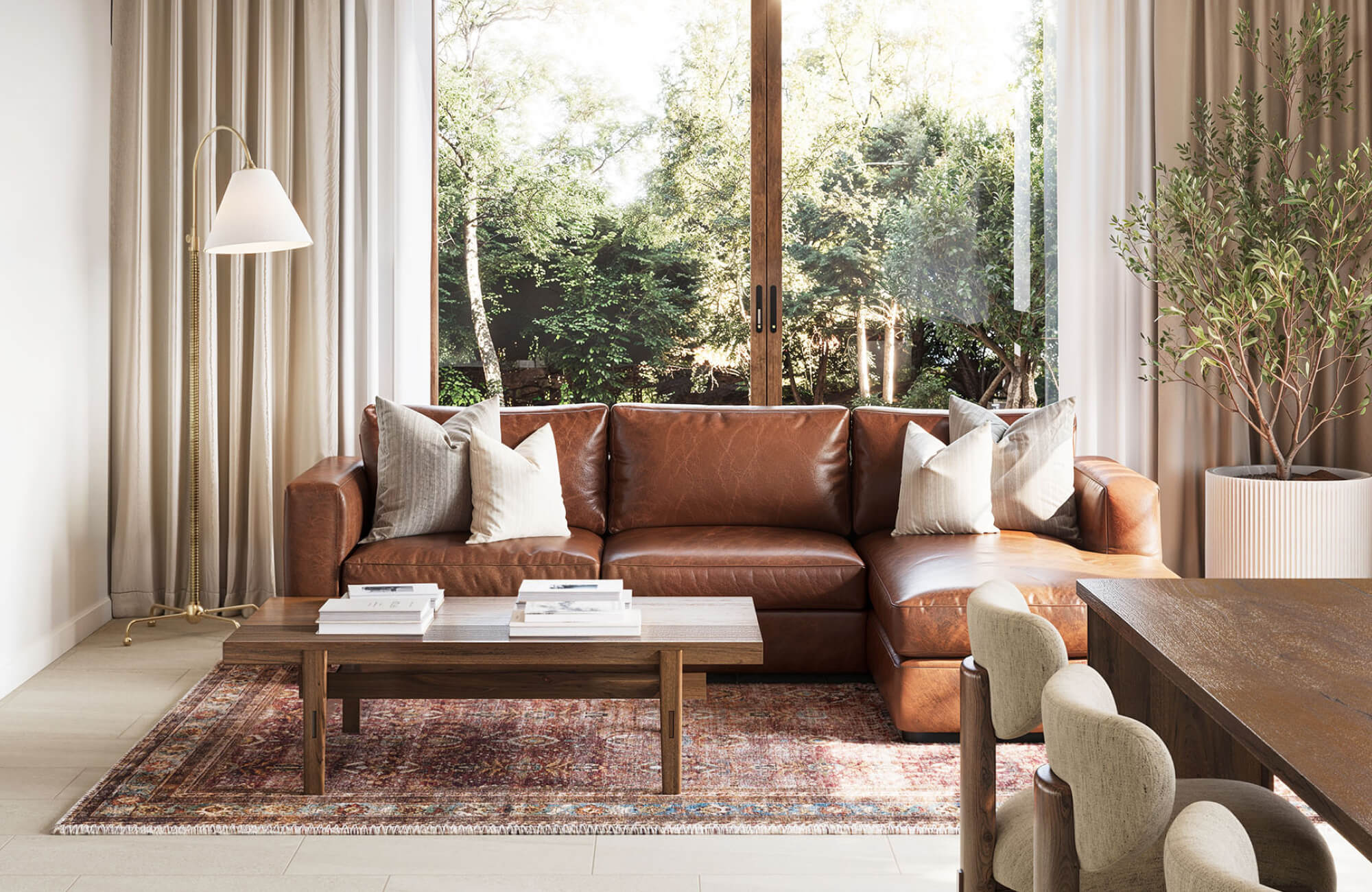 Warm and inviting living space with a rich leather sectional, vintage-style 9x12 rug, and floor-to-ceiling garden views.