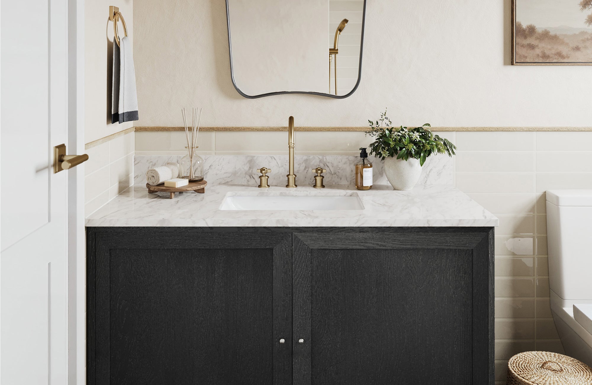 Compact black bathroom vanity with marble top, gold faucet, and soft beige wall tiles.