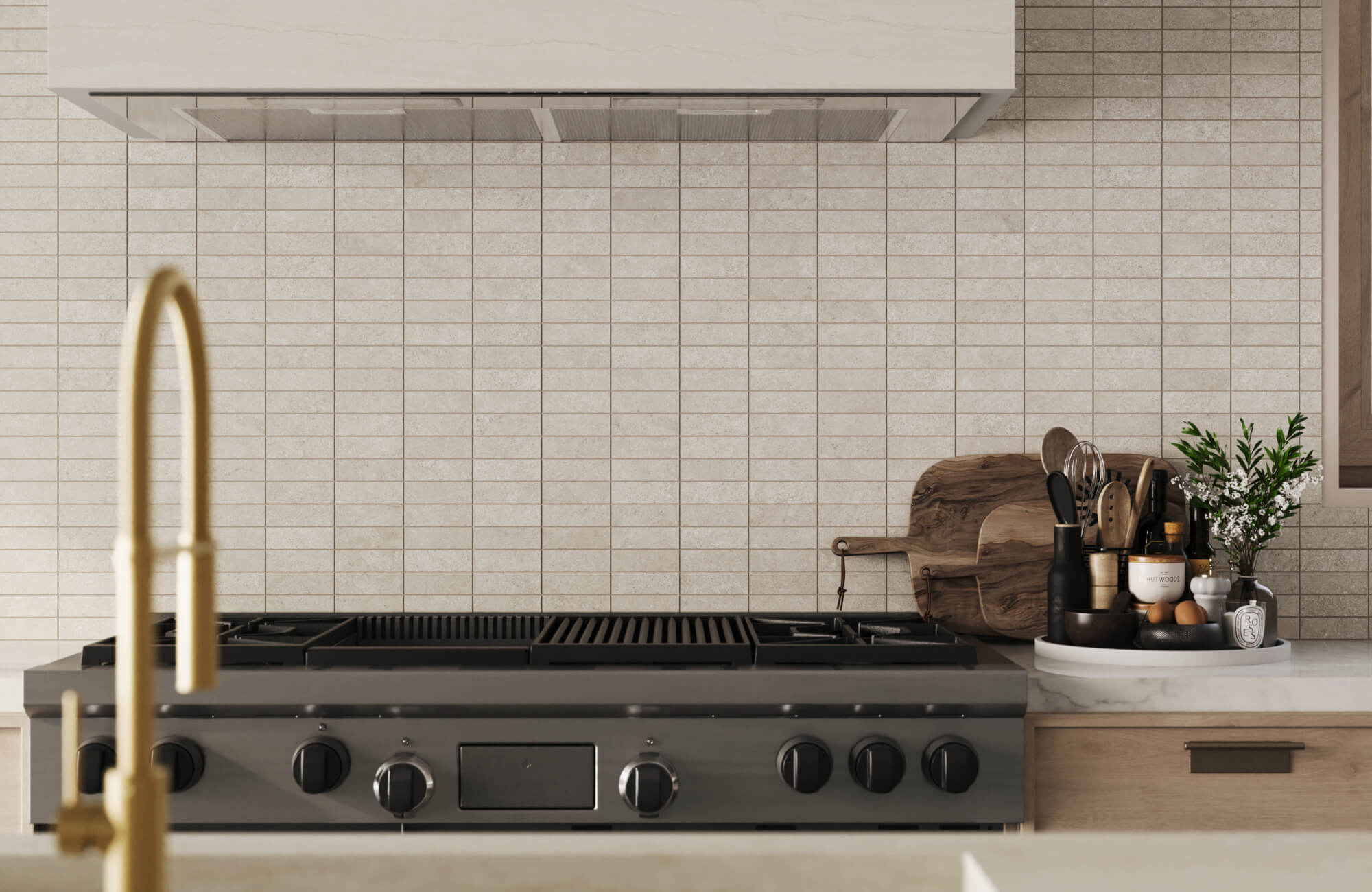 null Modern kitchen with a light beige mosaic tile backsplash behind a stainless steel gas range, wooden utensils, and decorative accents.