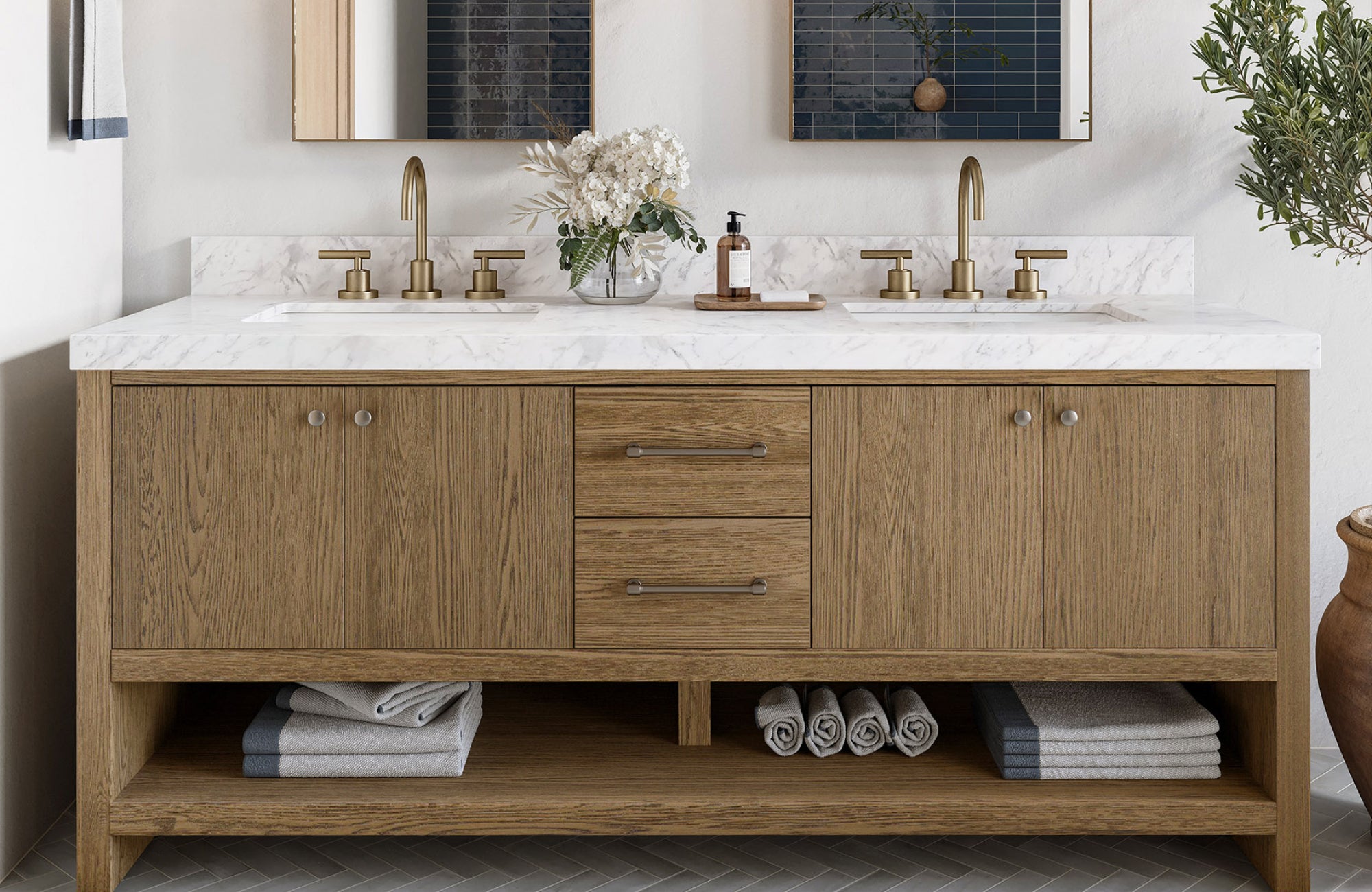 null Wide wood vanity with double sinks, white marble countertop, and open storage shelves holding folded towels.